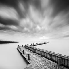 Molo di Wood su un lago durante una tempesta, foto a lunga esposizione in bianco e nero di un paesaggio acquatico
