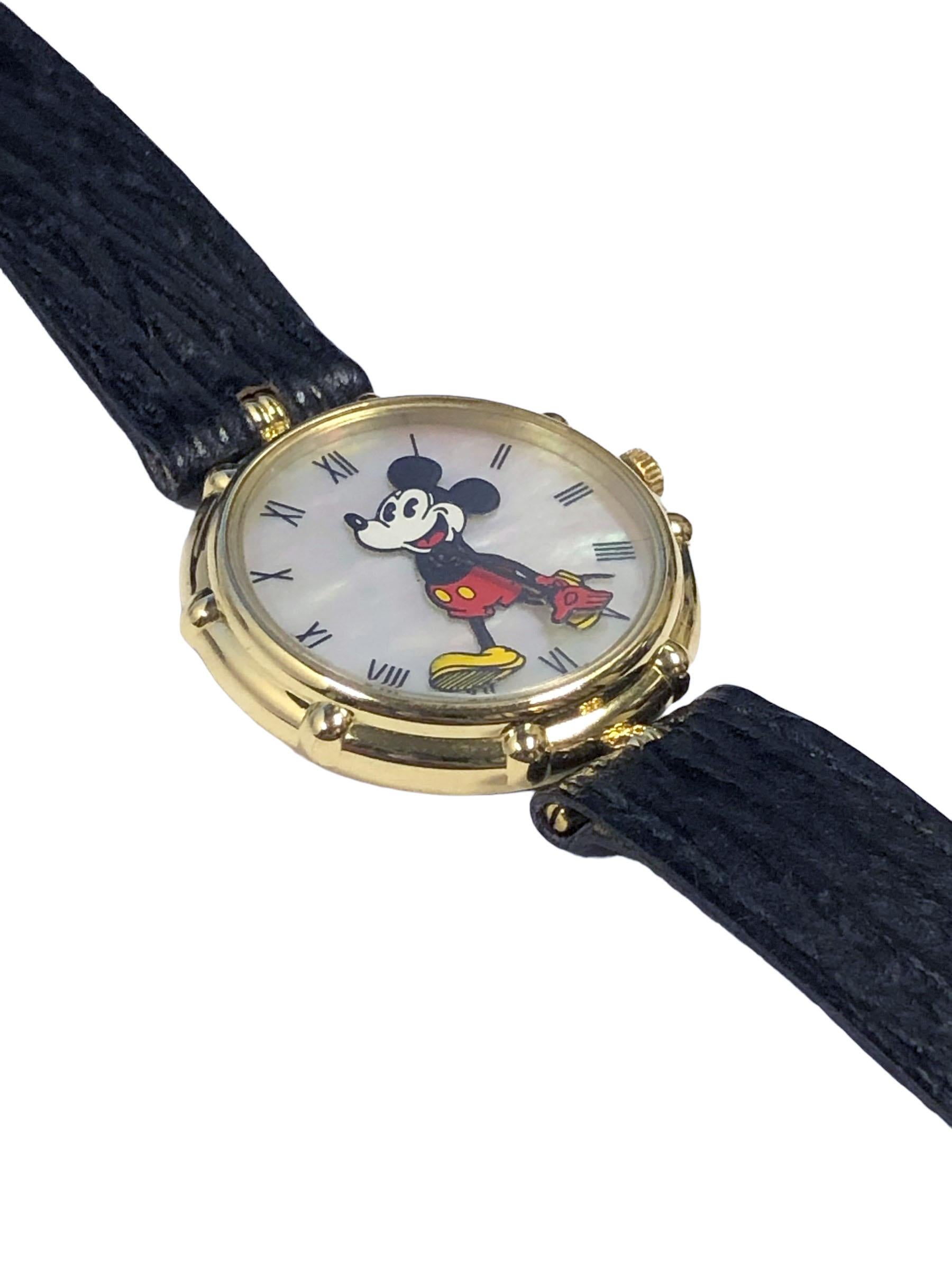 Circa 1990s Gerald Genta Mickey Mouse Wrist Watch, 30 MM 18K Yellow Gold 2 piece water resistant case. Quartz Movement, mother of Pearl Dial with black Roman numerals and an Enamel Mickey Mouse with Animated Hands.  Black Exotic Fred Paris strap