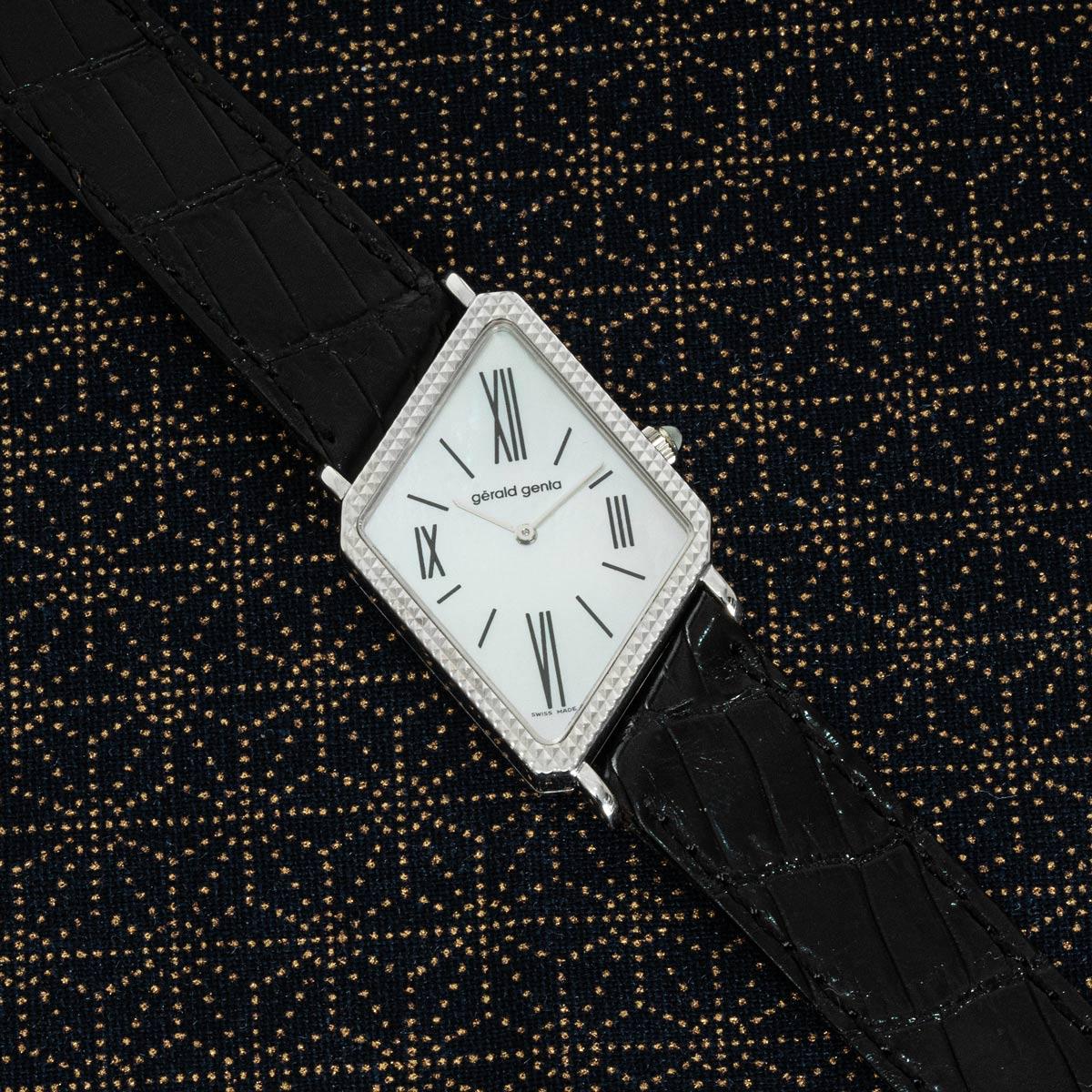 Une montre habillée Asymmetric en or blanc super rare de Gerald Genta, disponible dès maintenant dans notre Showroom à Londres.

Ce magnifique garde-temps affiche l'heure sur un cadran en nacre blanche avec des chiffres romains. Le cadran est