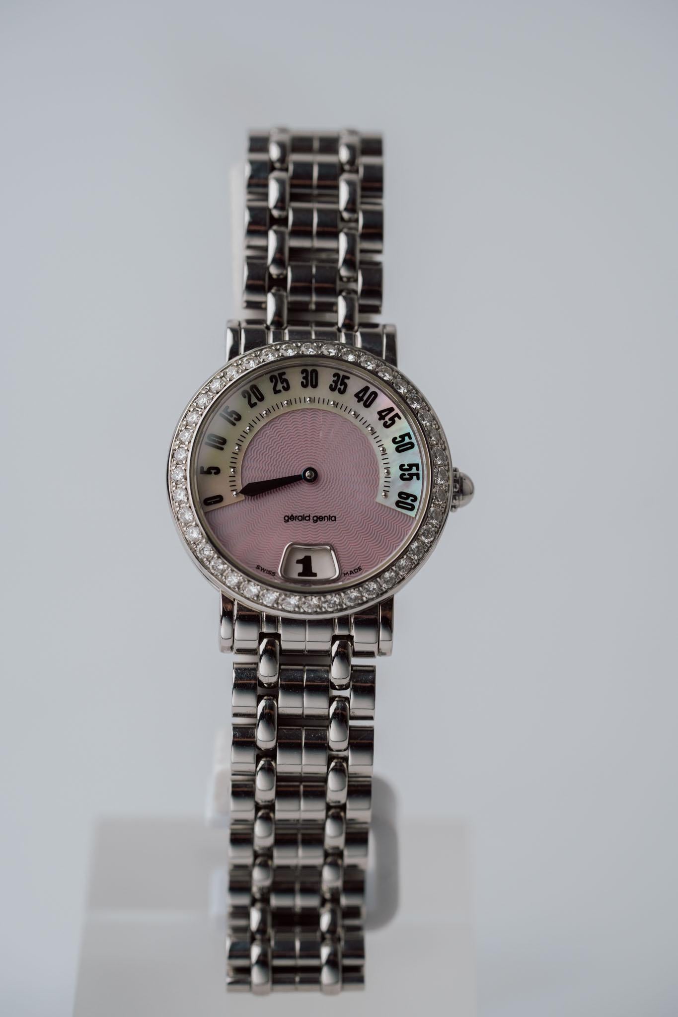 Gerald Genta Retro G.3624 - Rosa Perlmutt-Diamant-Sprungstunde (1990er Jahre)

Diese G.3624 aus den 1990er Jahren ist ein atemberaubendes Beispiel für Gerald Gentas ikonisches Retro Jump Hour Design und verbindet verspielte Eleganz mit innovativer