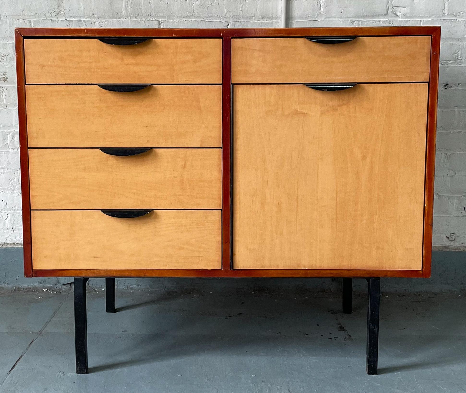 Case with five drawers and a cabinet of cherry-stained wood with faux-grain plastic laminate top and facings, curved steel drop pulls, steel angle-iron legs, and a perforated transite bottom panel. Designed by Gerald Luss in 1951 for private rooms