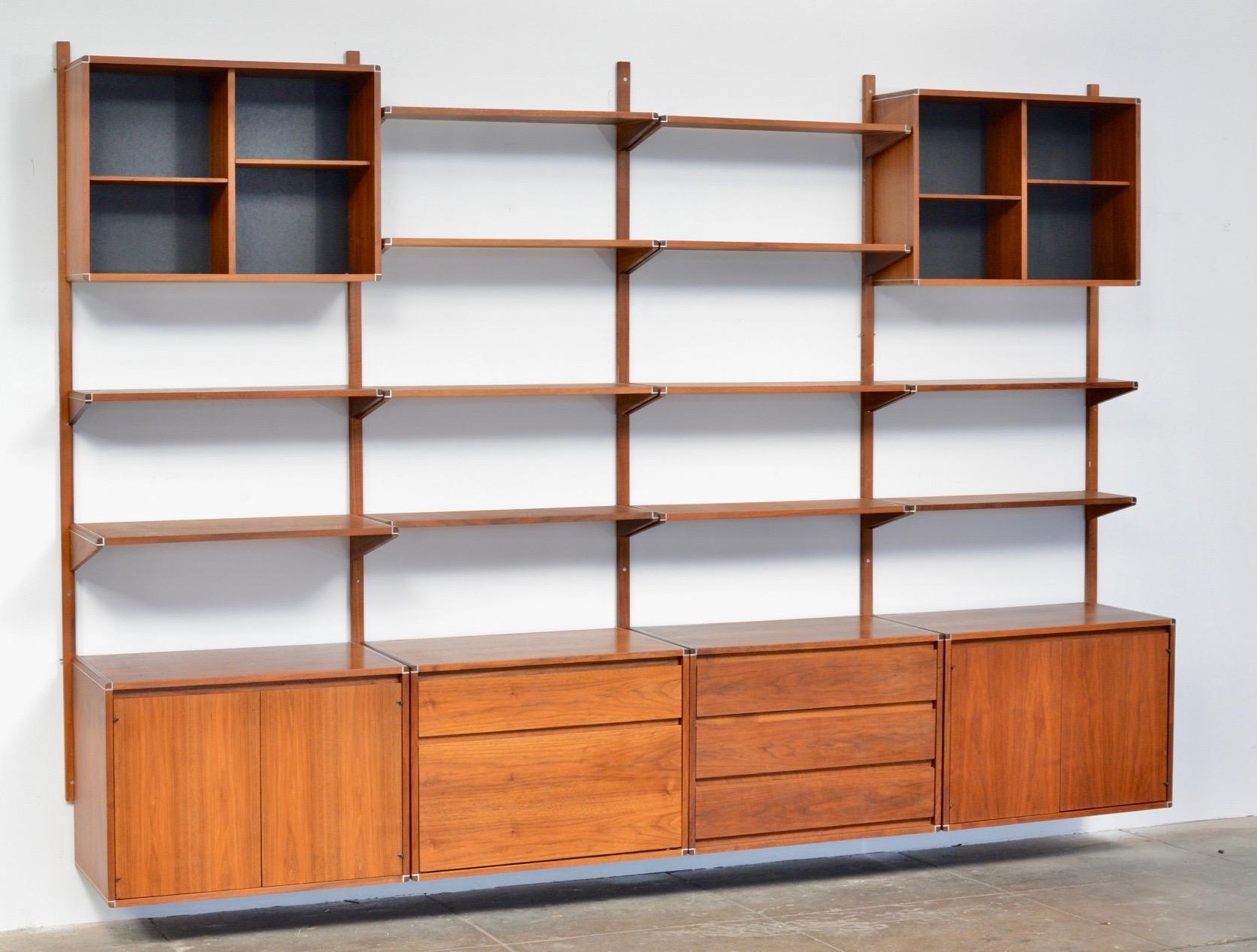 This is a four bay Barzilay wall unit by Gerald McCabe of Los Angeles. Oiled walnut with aluminum detail in great condition. We have a variety of cabinets, shelves, and desk components, you can customize your order depending on configuration
