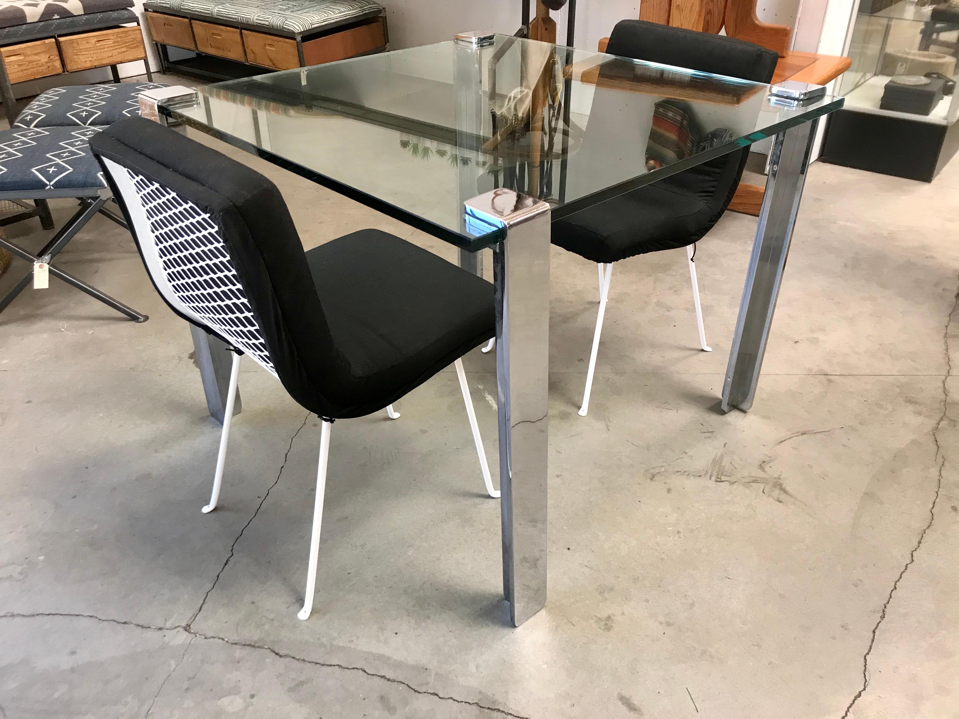 California design.
Limited.
From his Eon line.
Thick glass with four chrome plated heavy steel bases that clamp onto the glass. 
There are bolts under the clamps that can be loosened for removal and tightened for stability.
Nice modernist