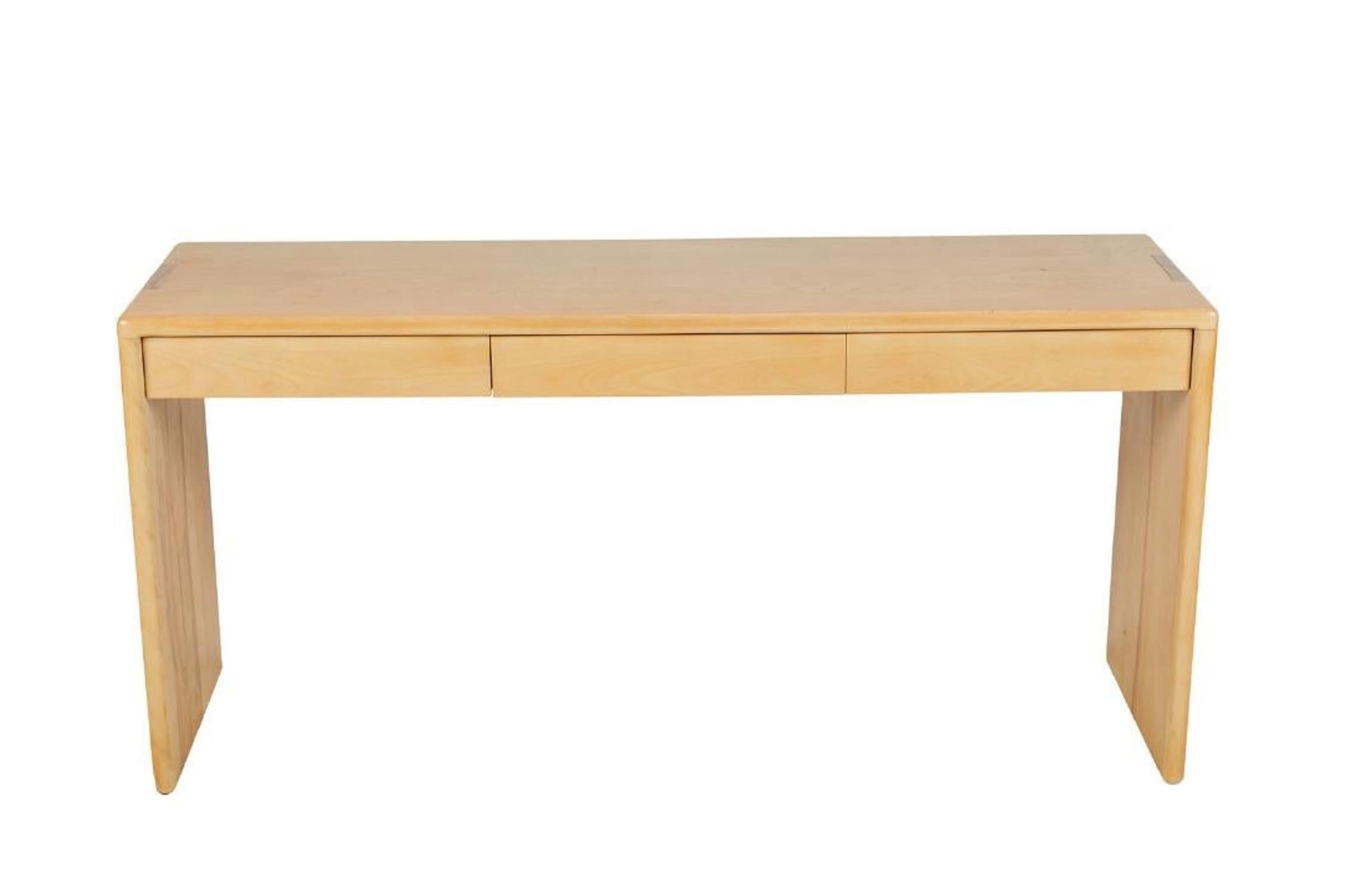 Gerald McCabe three-drawer console table, in light wood finish.