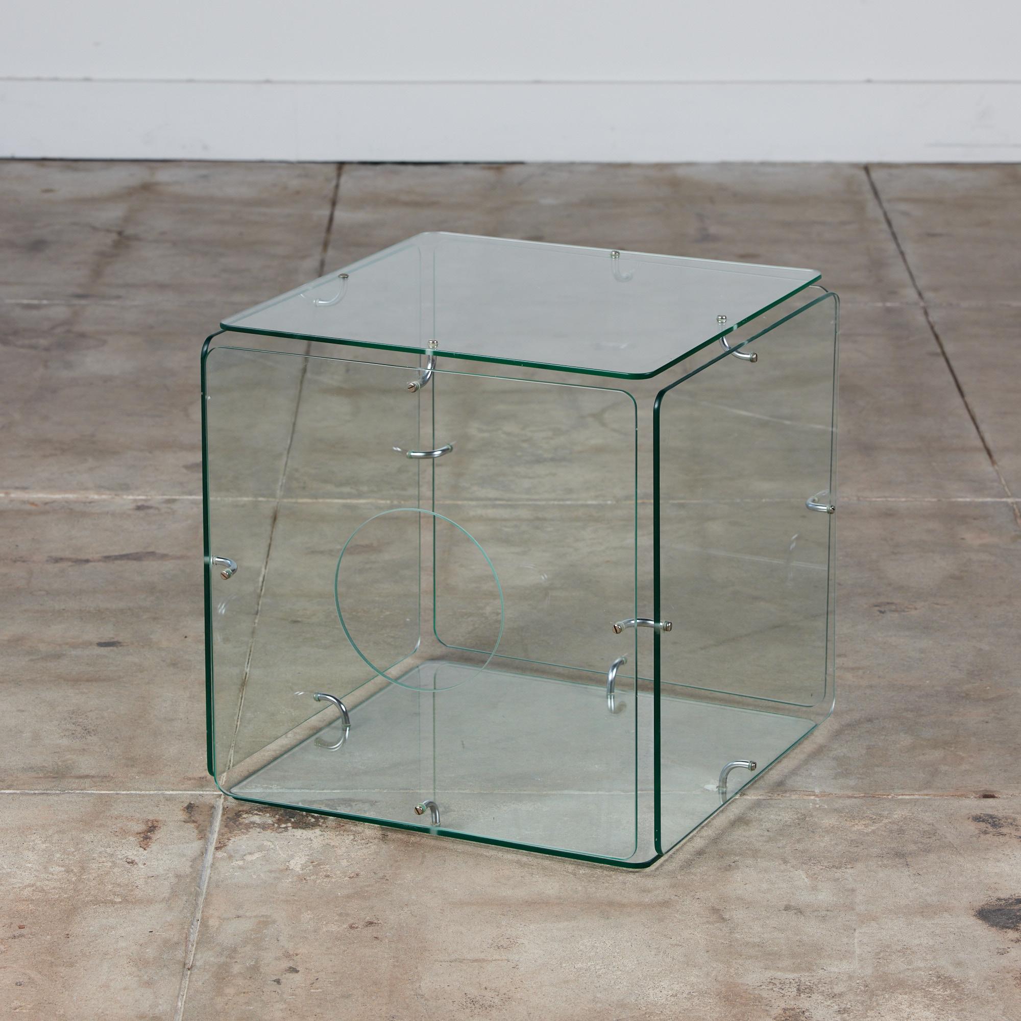 Gerald McCabe glass cube table, c.1960s, USA is a minimalist design that stands the test of time. This piece features six square glass sides with rounded edges. It is held together with curved steel chrome plated hardware. One side contains a