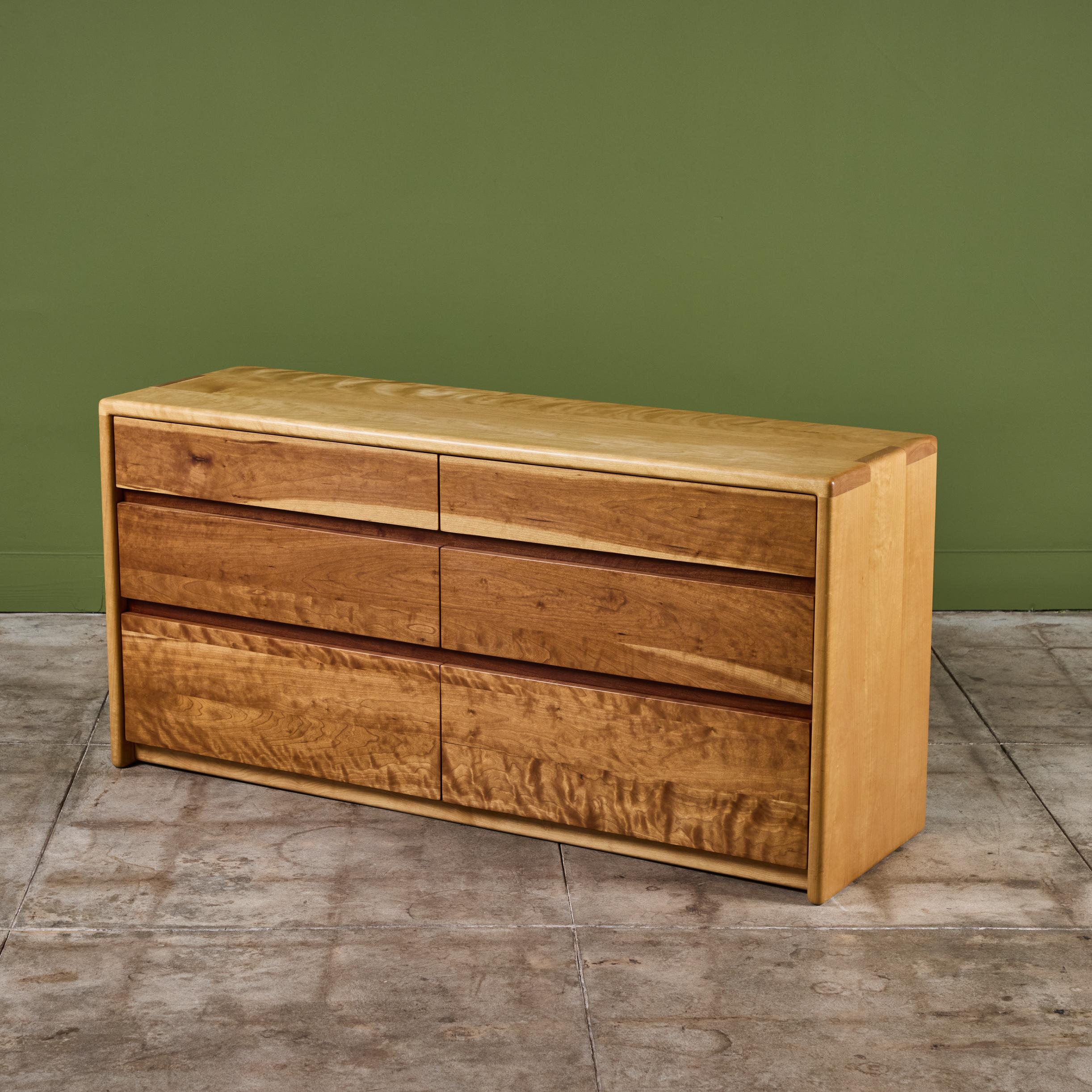 Cómoda de Gerald McCabe para Eon Furniture, c.1997, EE.UU. La cómoda de madera enmarcada en arce, presenta suaves bordes redondeados con detalles de finger joint en los bordes. Los seis cajones de frente plano son de madera de shedua. Esta pieza