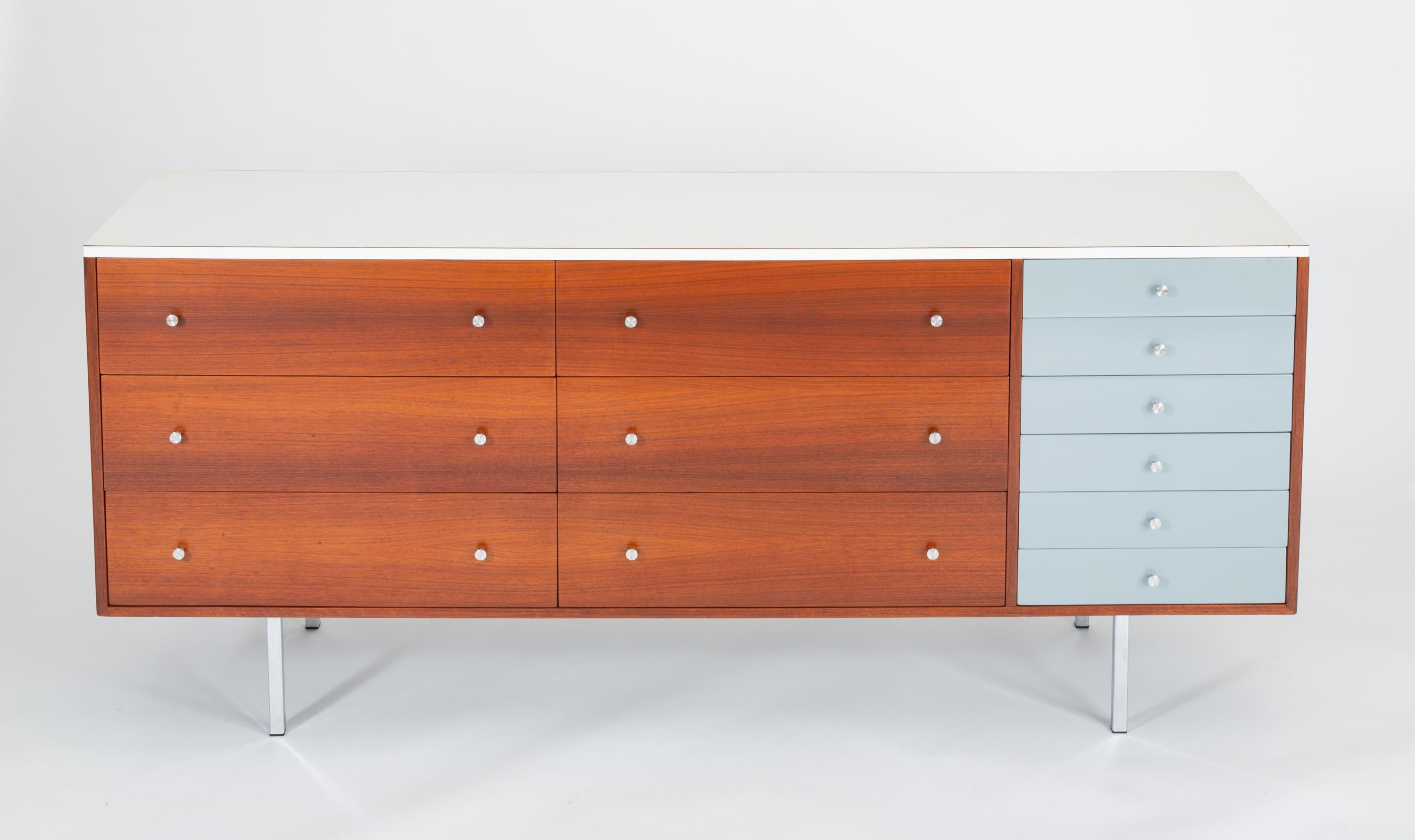 A late 1950s custom-built dresser by California designer and craftsman Gerald McCabe has a walnut body with a white laminate top. The case contains six large, deep drawers with walnut panels next to a single stack of six smaller drawers painted in a