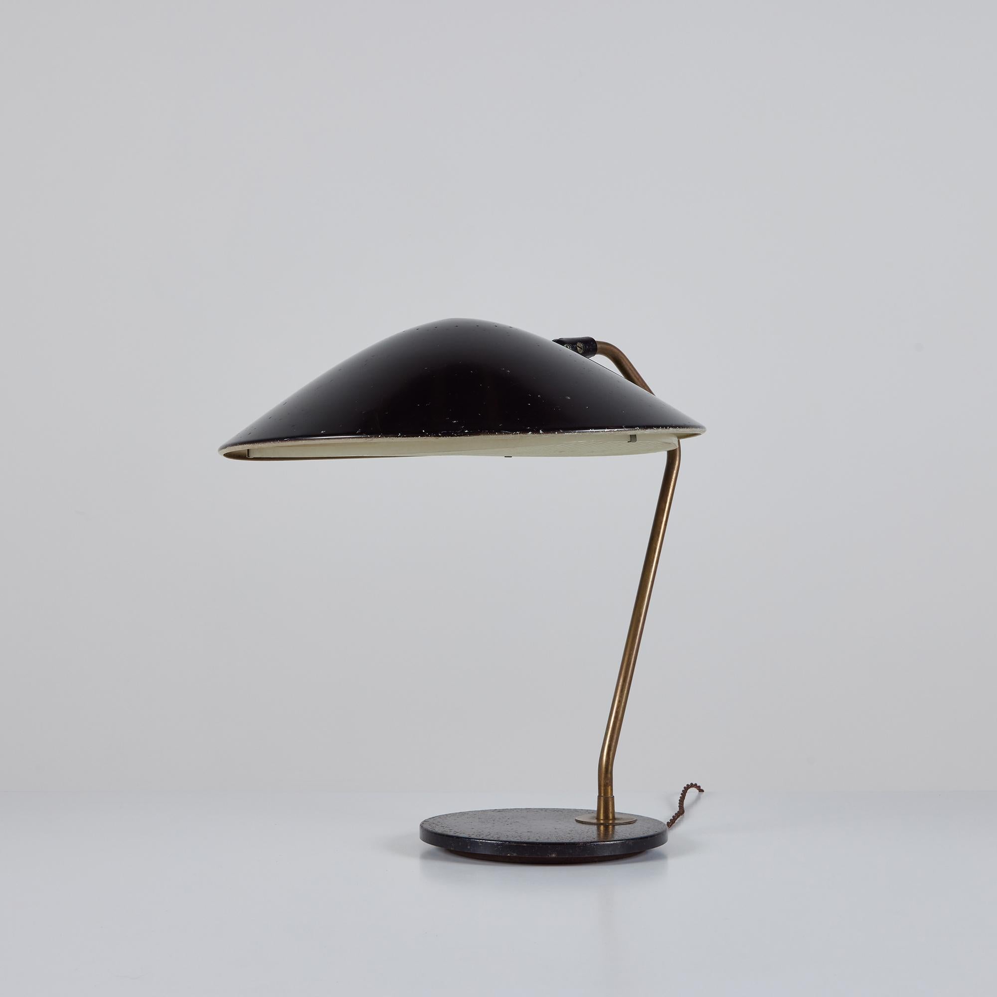 Gerald Thurston desk or table lamp for Lightolier, c.1950s, USA. The lamp features a black enamel dome aluminum shade. The shade has a round perforated detailing at the top and a translucent light diffuser at the bottom of the shade. A curved brass
