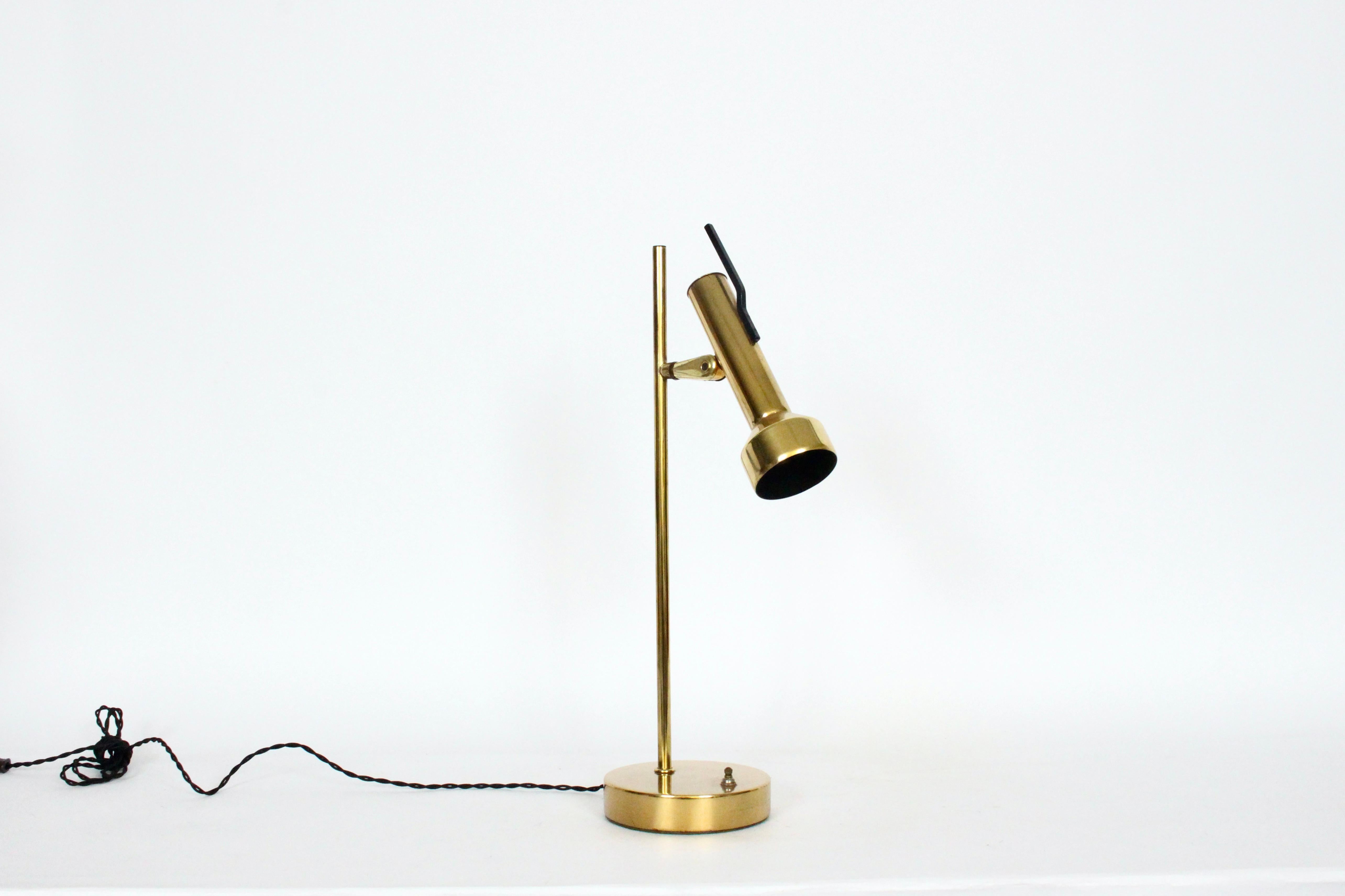 American Mid-Century Modern Gerald Thurston for Lightolier style brass desk lamp.  Featuring a slender, sturdy Brass plated tubular stem, round balanced, weighted 6D base, turn switch to base, adjusting Black enameled interior Brass shade head (8.25