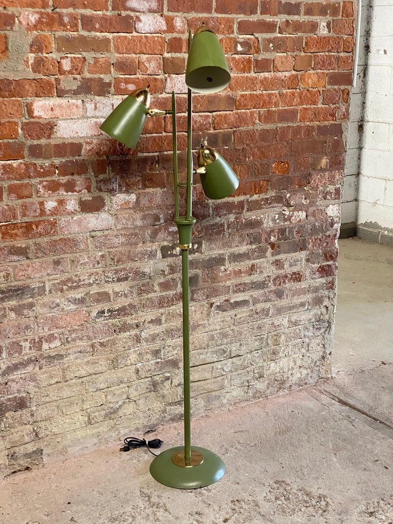 Three light Gerald Thurston designed floor lamp for Lightolier. Circa 1960-70. Avocado enamel with brass finish fittings and accents. You can light one, two or all three at the same time or individually. Adjustable cone shades that have retained