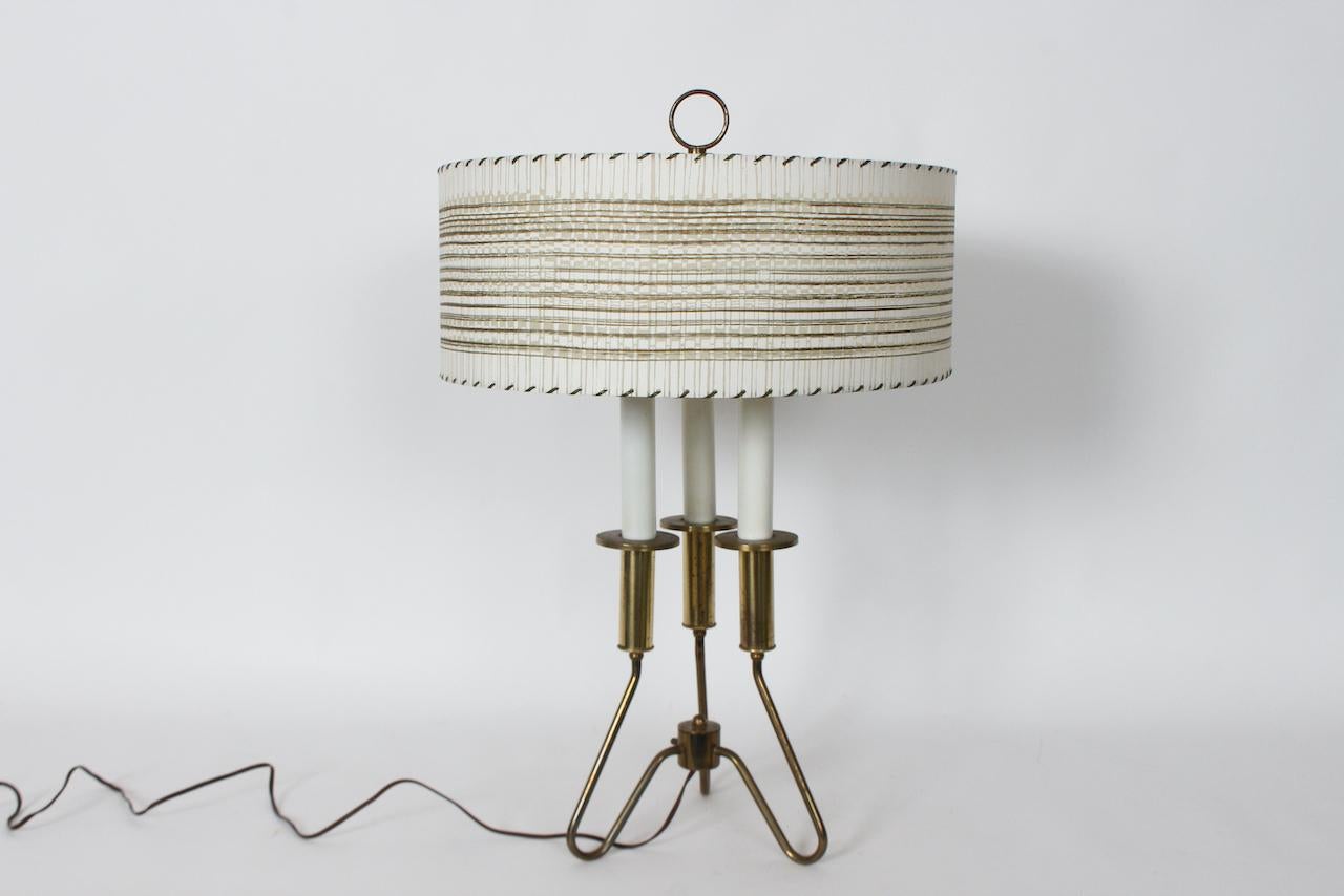 Gerald Thurston for Lightolier Hollywood Regency Candlestick Table Lamp. Whiting : base en laiton courbée, trois chandeliers en métal blanc émaillé, fleuron en laiton, abat-jour en parchemin beige clair à bandes horizontales et surpiqûres brunes (18