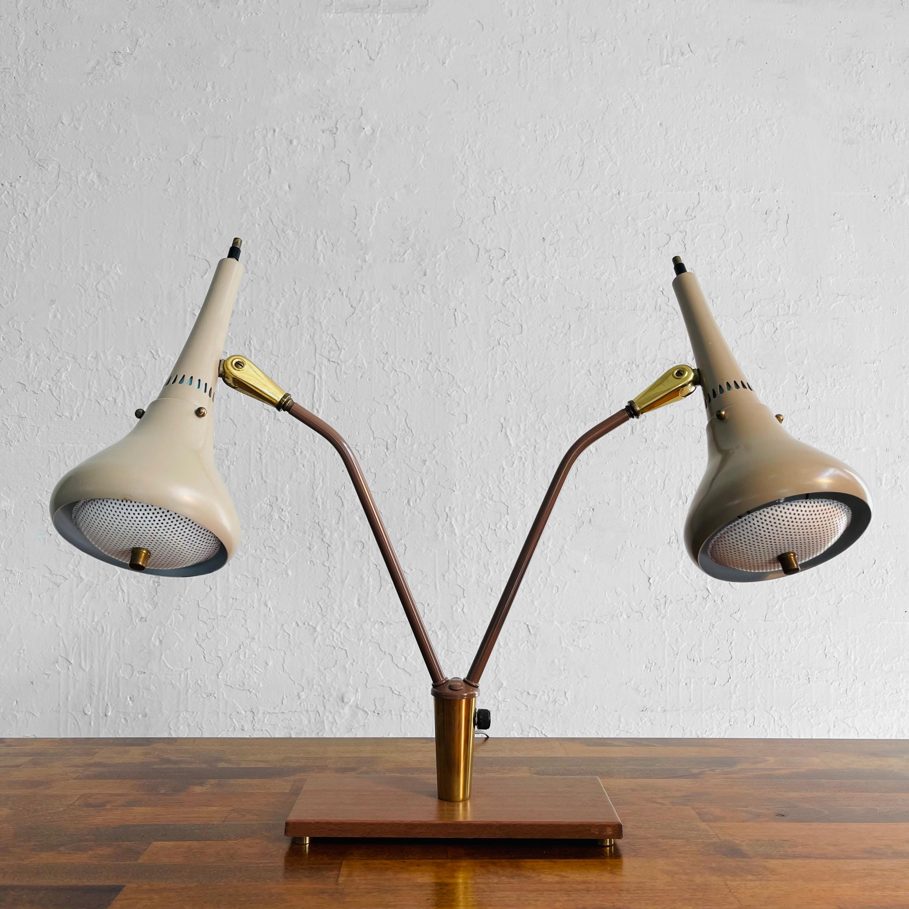 Classic, Mid-Century Modern, double-headed desk lamp by Gerald Thurston for Lightolier features painted metal shades with perforated diffusers and brass accents on a faux wood metal base. The lamps articulate as shown. Both shades are the same light
