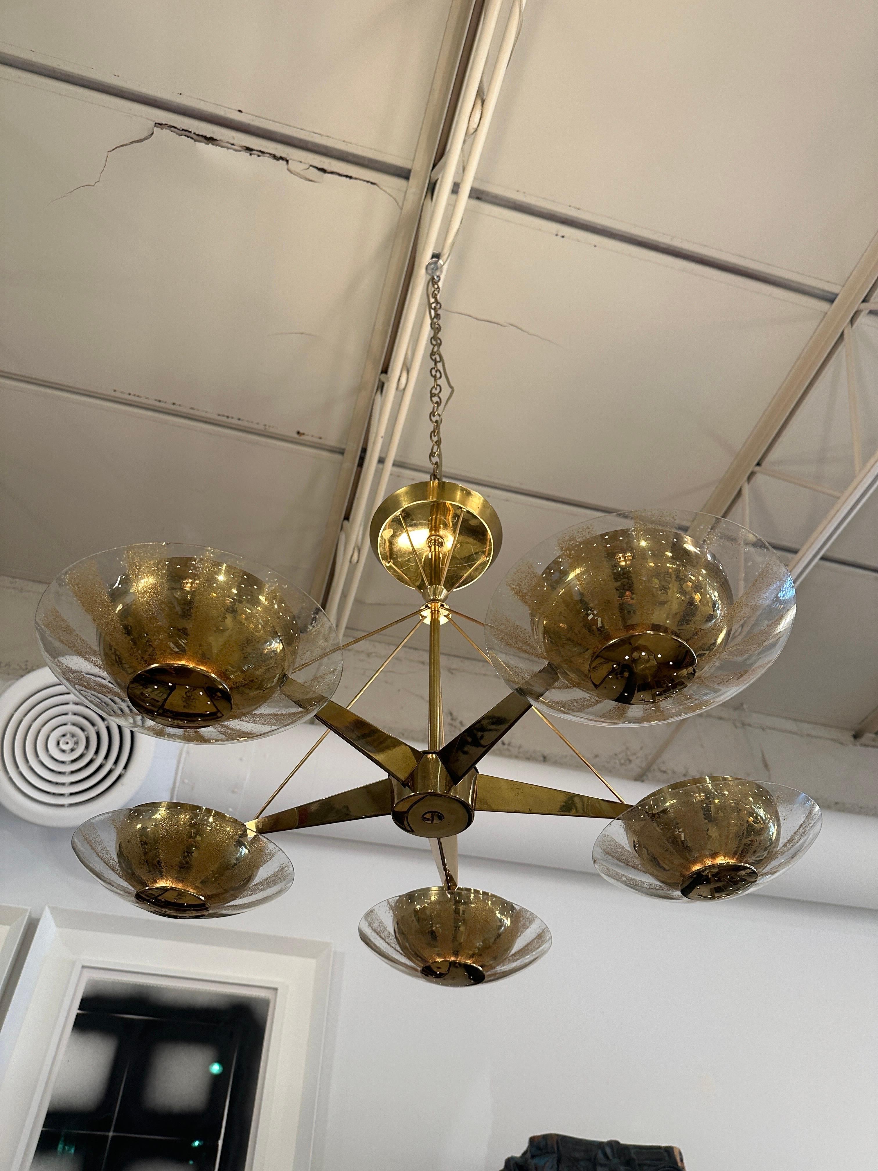 Original vintage LIGHTOLIER Five light - Five arm chandelier with perforated brass diffusers and gold frosted glass shades.  Futuristic brass rods extending from center to meet canopy.  Lightolier paper label on canopy.  Sourced from the Francis J.