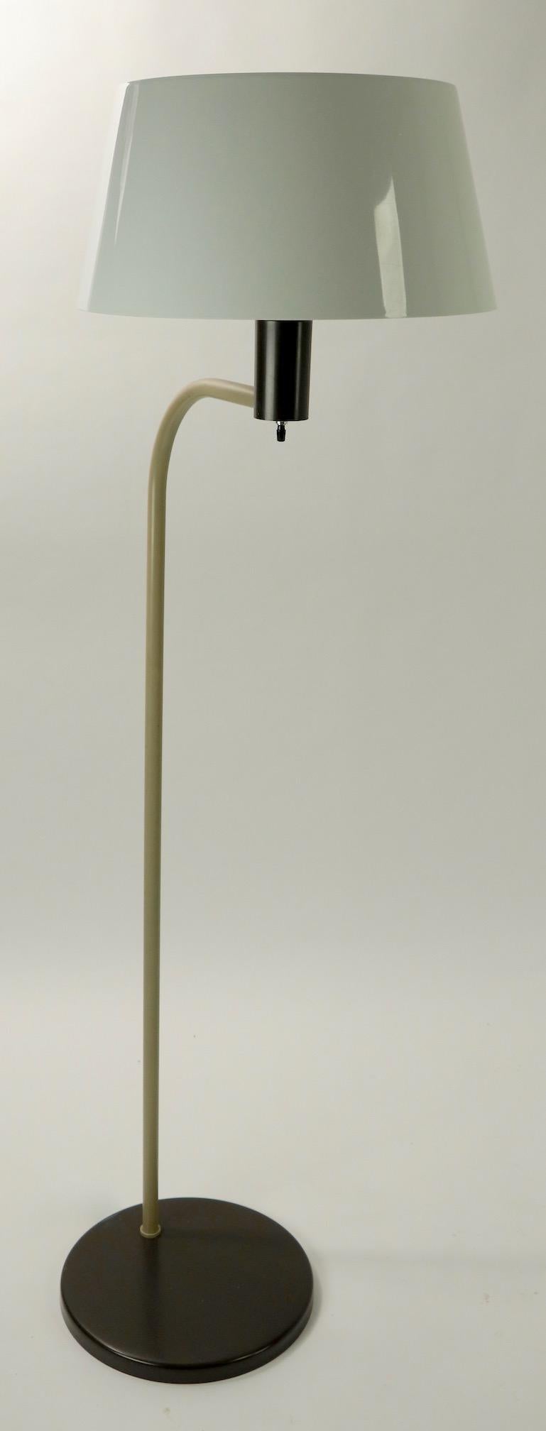 Cool Postmodern Gerald Thurston design for Lightolier floor lamp, in extra clean, original and working condition. The lamp has a white plastic shade and two-tone metal base.
Measures: Diameter of shade 13.5 x height of shade 7 x arm projection 17 x