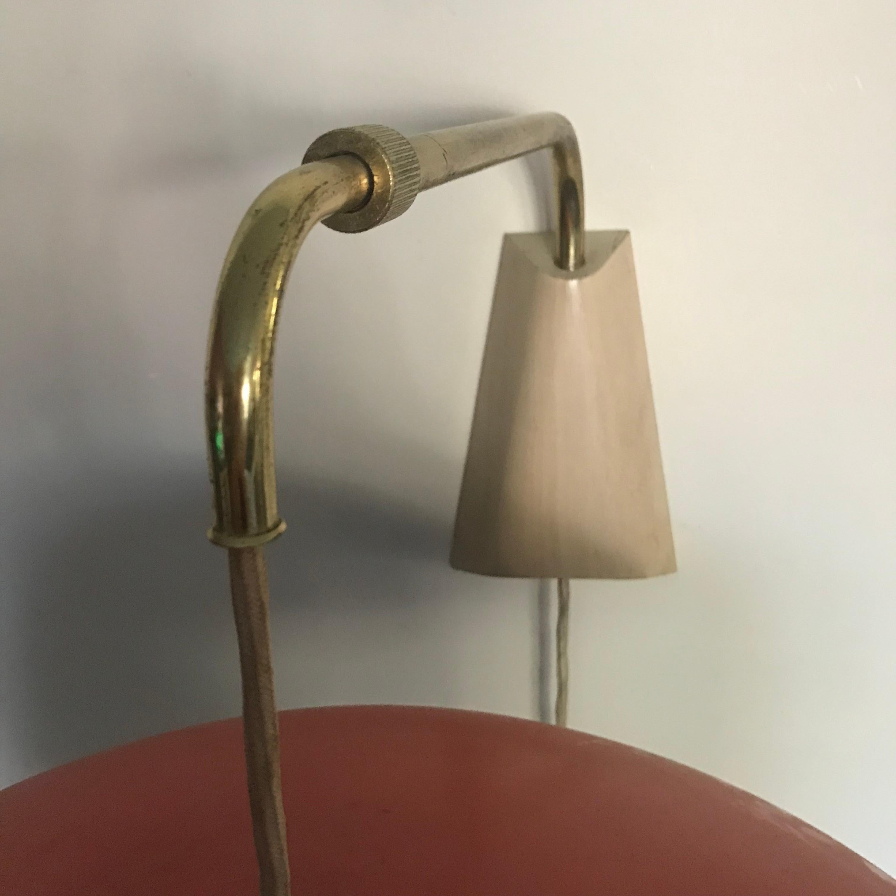 Original Gerald Thurston for Lightolier domed metal wall hanging reading light. The sleek design consists of a Brass articulating arm with integrated pulley system.