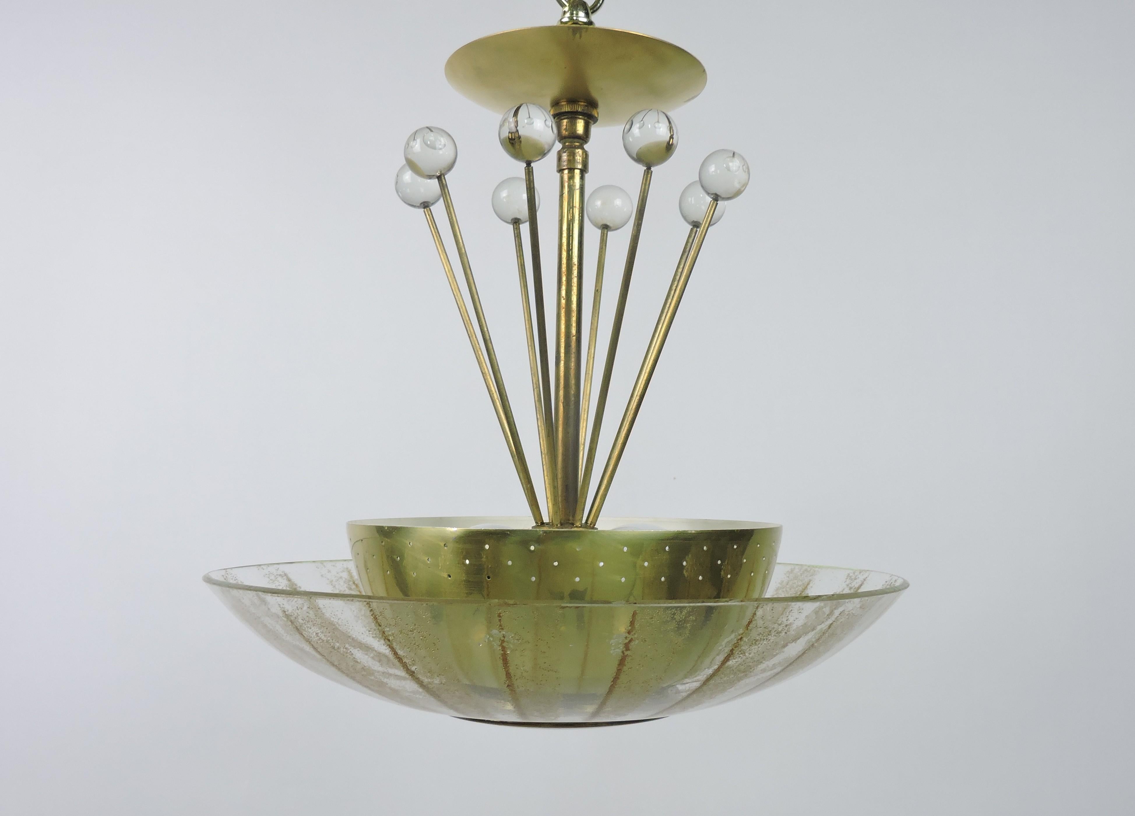 Beautiful and rare mid century modern 1950s pendant lamp designed by Gerald Thurston and made by high quality manufacturer, Lightolier, as part of its Claremont Light series. This lamp has a perforated brass diffuser that rests on a glass diffuser