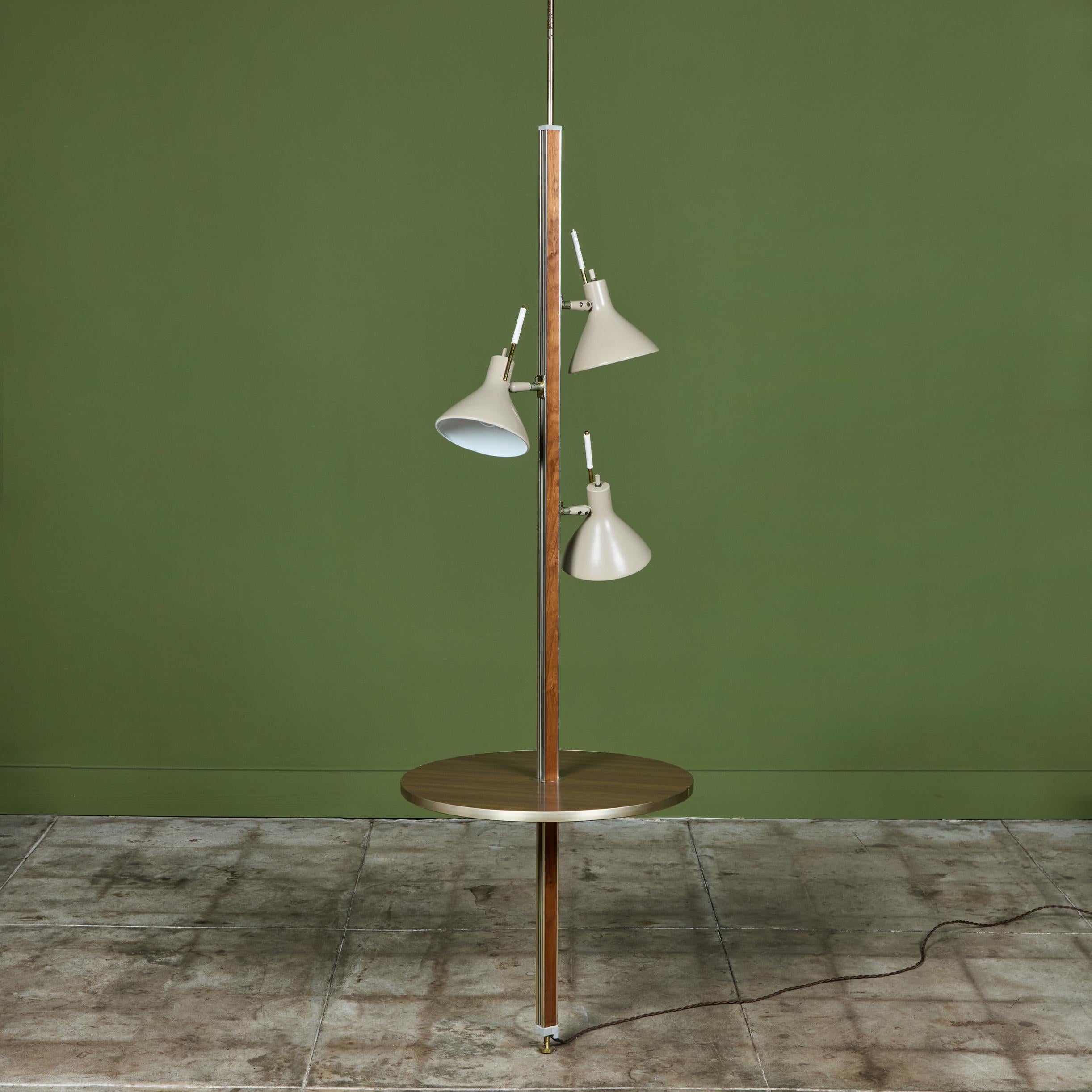 Three shade tension pole floor lamp by Gerald Thurston for Lightolier. Distinguished by the unique beige enameled shades, this lamp provides three-directional illumination from adjustable spots. The central column is Formica and brass, with a