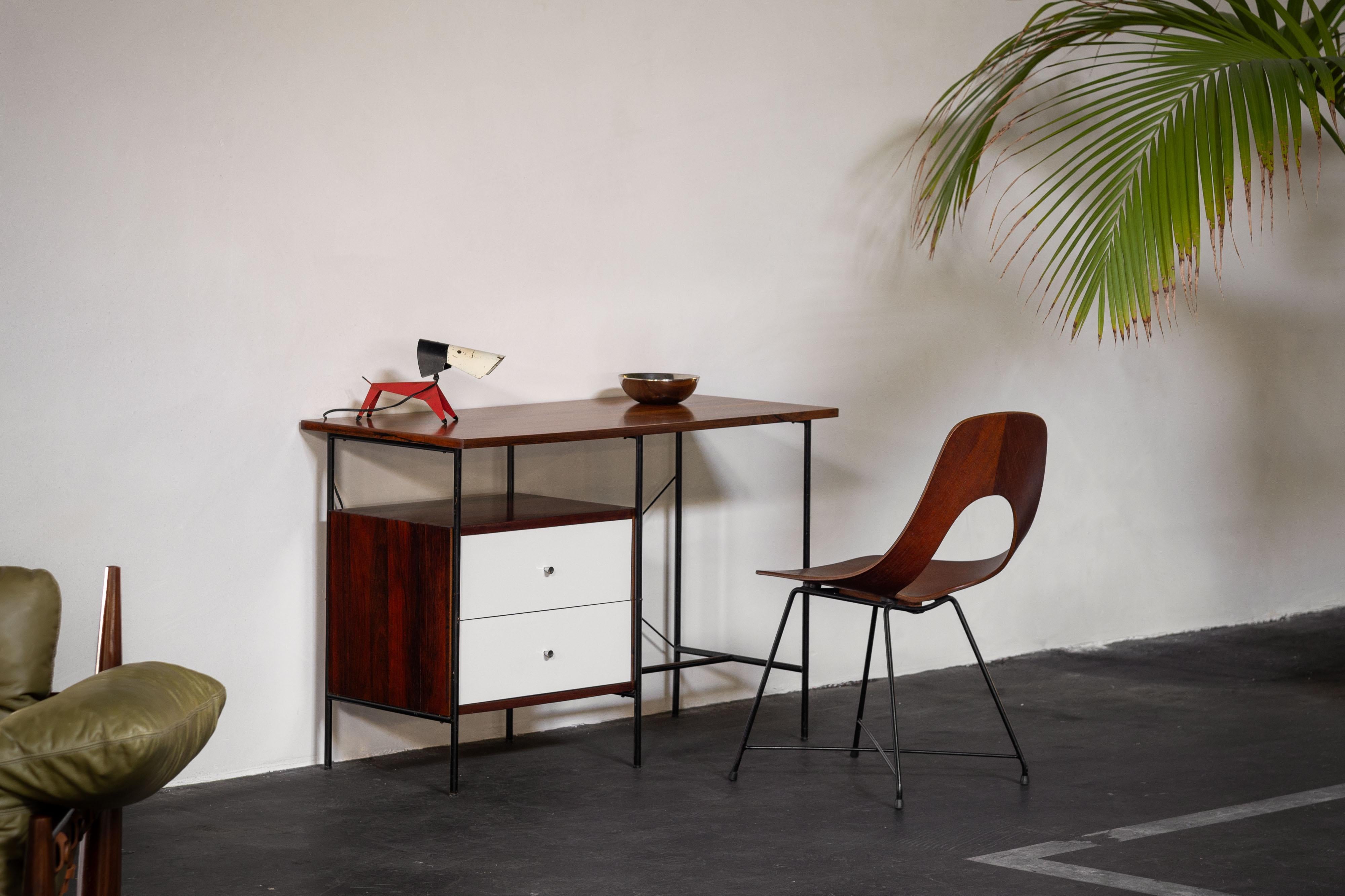 Very nice minimalistic small writing desk designed by Geraldo de Barros and manufactured by Unilabor, Brazil 1956. The desk is made up of three main parts. The black iron frame, rosewood finished top and the drawer cabinet. The drawer fronts have