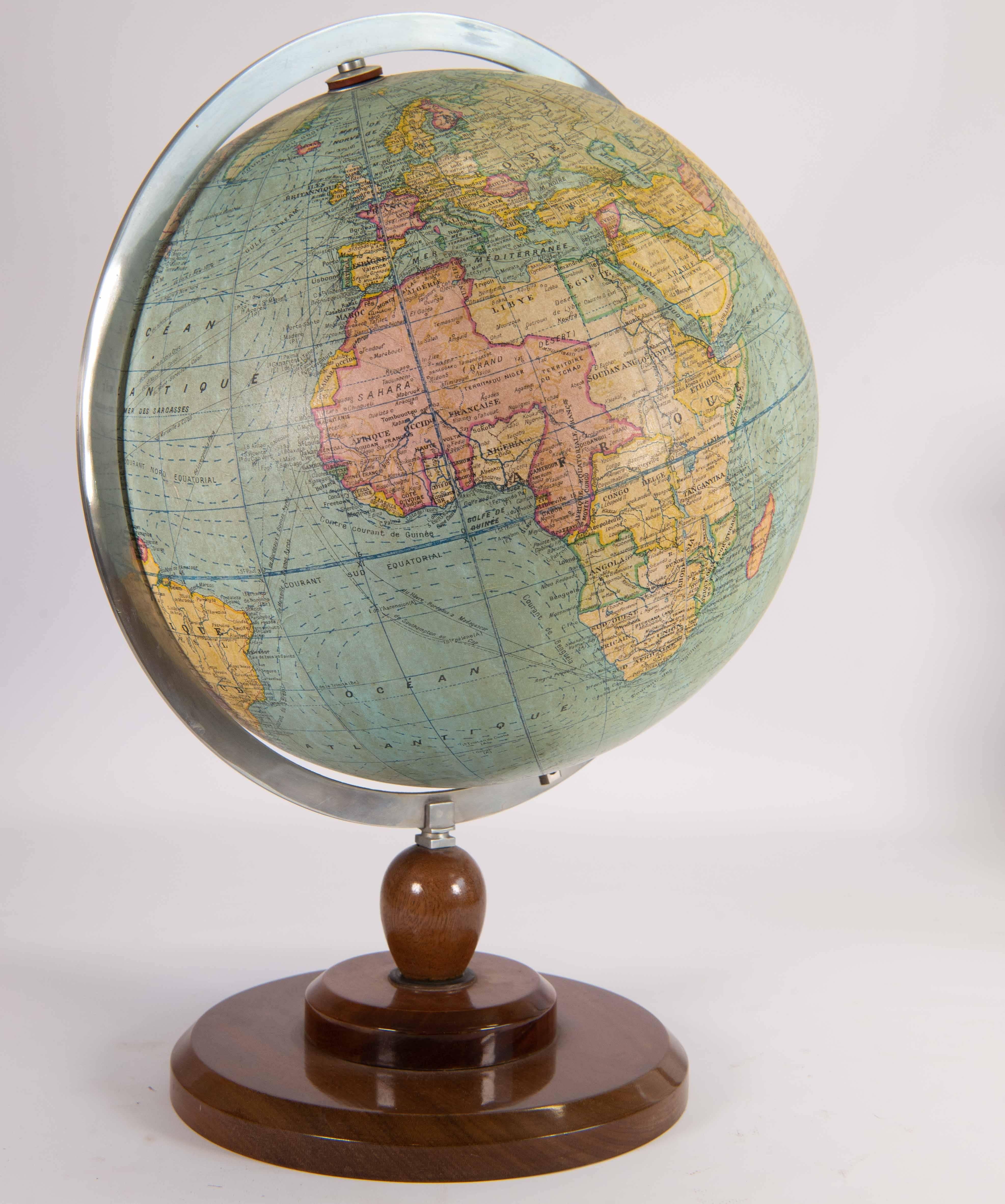 Globe displaying the world map on a 1:40 000 000 Meter scale. Made by Gerard Barrère et Thomas, circa 1950. 
Globe rotates within metal ruler. Ruler rotates on wood base. 
Language on the globe is French. 

Please note: This globe is available