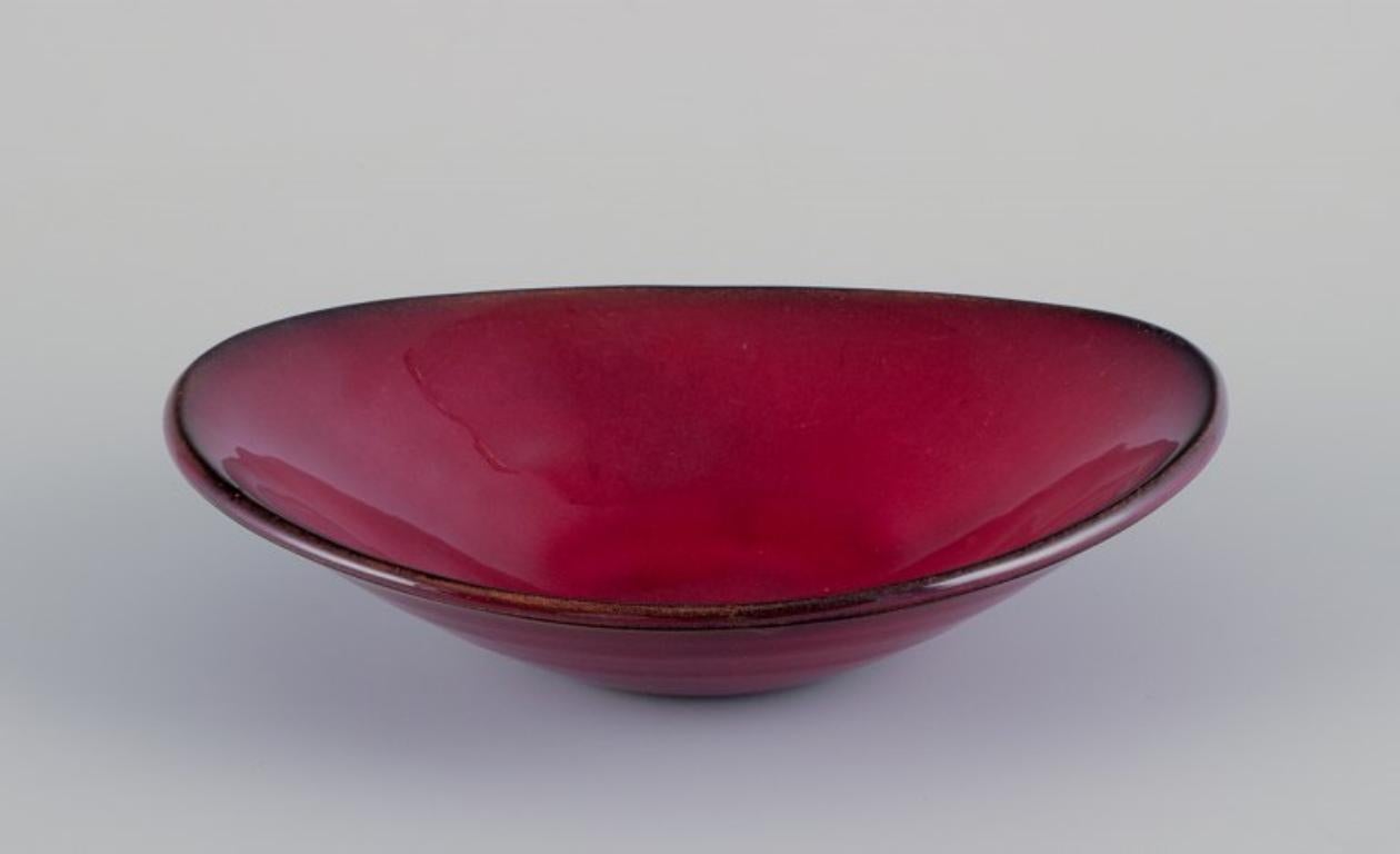 Gerard Hofmann (1917-1965), French ceramicist, own workshop. 
Bowl with ox blood glaze. Handmade.
Circa 1960.
In perfect condition.
Signed.
Dimensions: L 21.0 cm x H 5.0 cm.