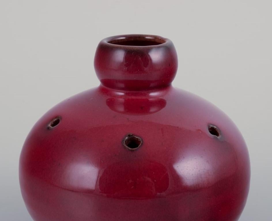 Moderne Gerard Hofmann, céramiste français. Vase perforé avec glaçure sang de bœuf.