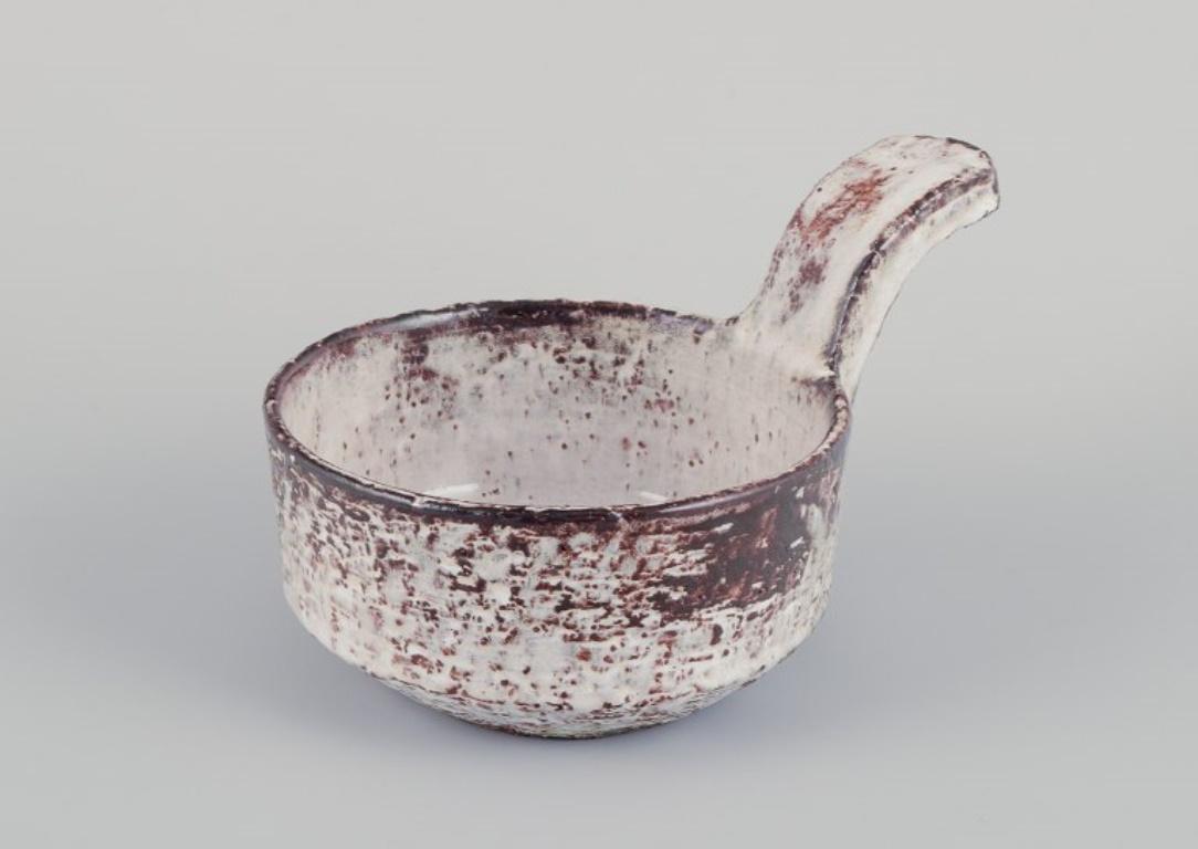 Gerard Hofmann (1917-1965), French ceramicist, own workshop. 
Two unique ceramic pieces: a pitcher and a handled bowl. 
Earth-toned glaze. Handmade.
Circa 1960.
In perfect condition.
The bowl is signed.
Pitcher: W 15.0 cm, including the handle and