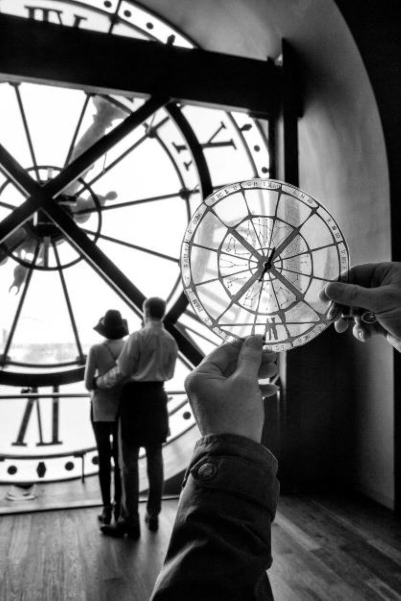 Gérard Uféras Black and White Photograph - A day in the museum - people in front of window with clock looking outside