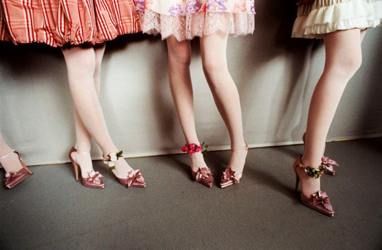 Color Photograph di Gérard Uféras - Christian Lacroix Haute Couture - modelle nel backstage che mostrano gambe, scarpe e abiti
