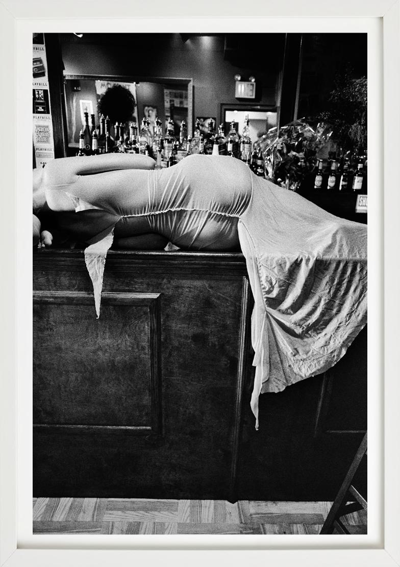 Elisa Jimenez, Ready to Wear 2000, NY, Foto en blanco y negro de una mujer en la barra del bar - Photograph de Gérard Uféras