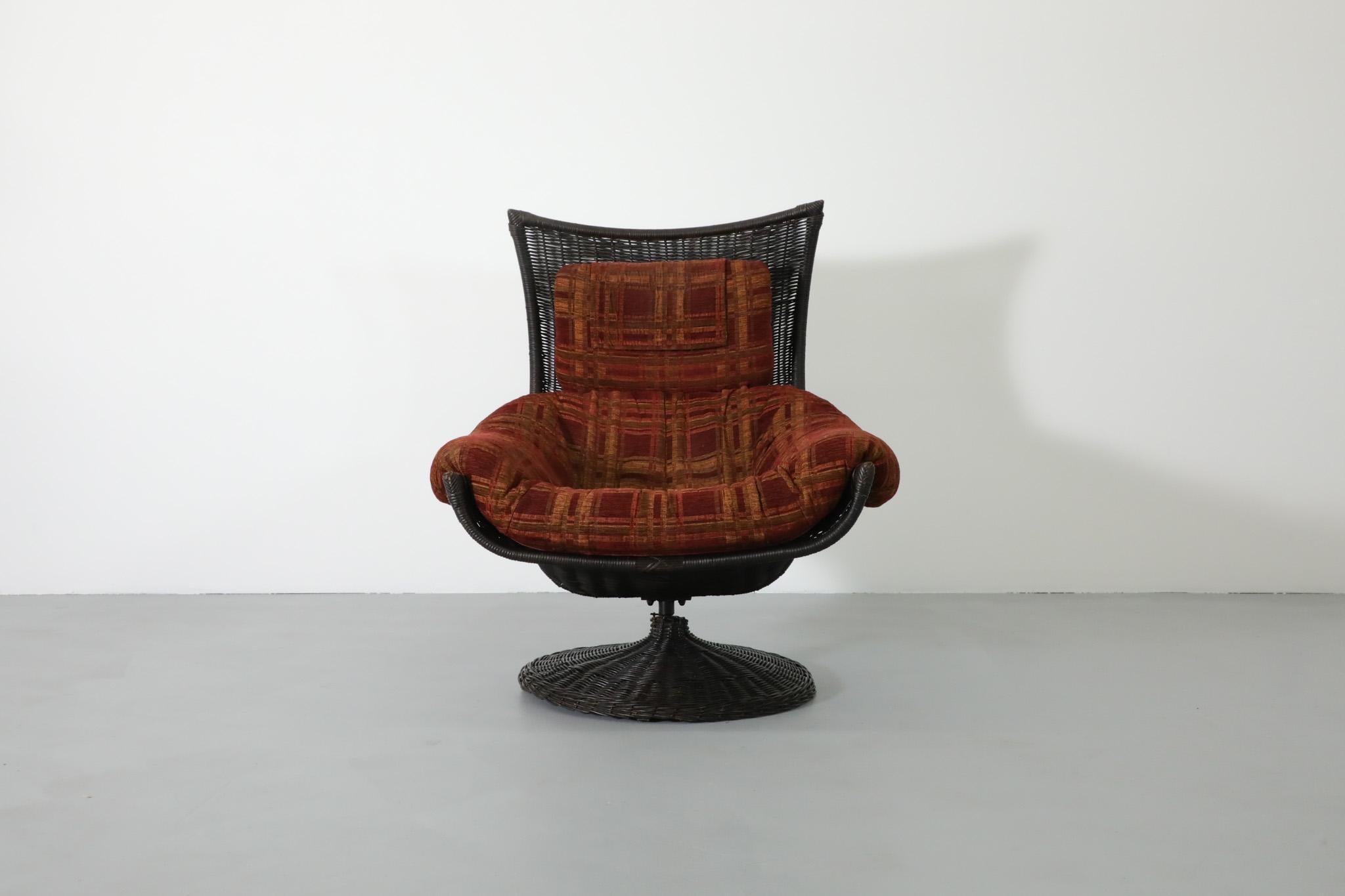 Impressive, Mid-Century Gerard van den Berg designed swivel lounge chair for the Dutch Montis company. Its black woven rattan seat sits on a sturdy metal frame with an attractively patterned red fabric cushion and headrest. This beautiful lounge