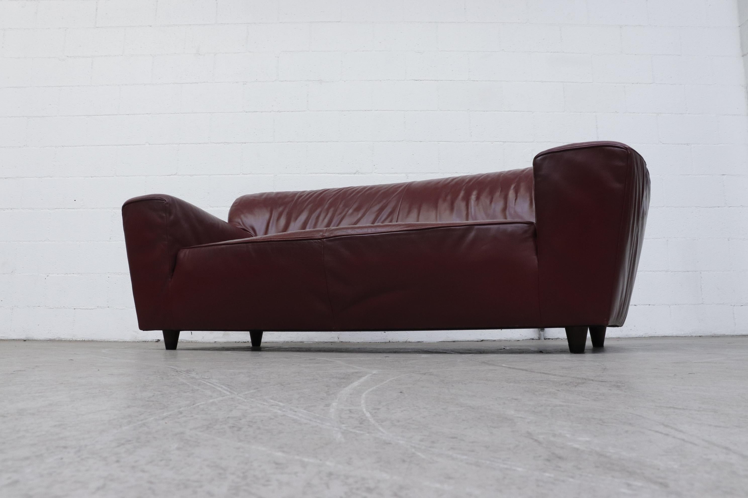 Midcentury Gerard Van Den Berg 'Corvette' sofa in Bordeaux leather with short stubby wood legs. In original condition with visible wear and scratching consistent with age and use. Another 'Corvette' sofa also available (LU922421844162).
