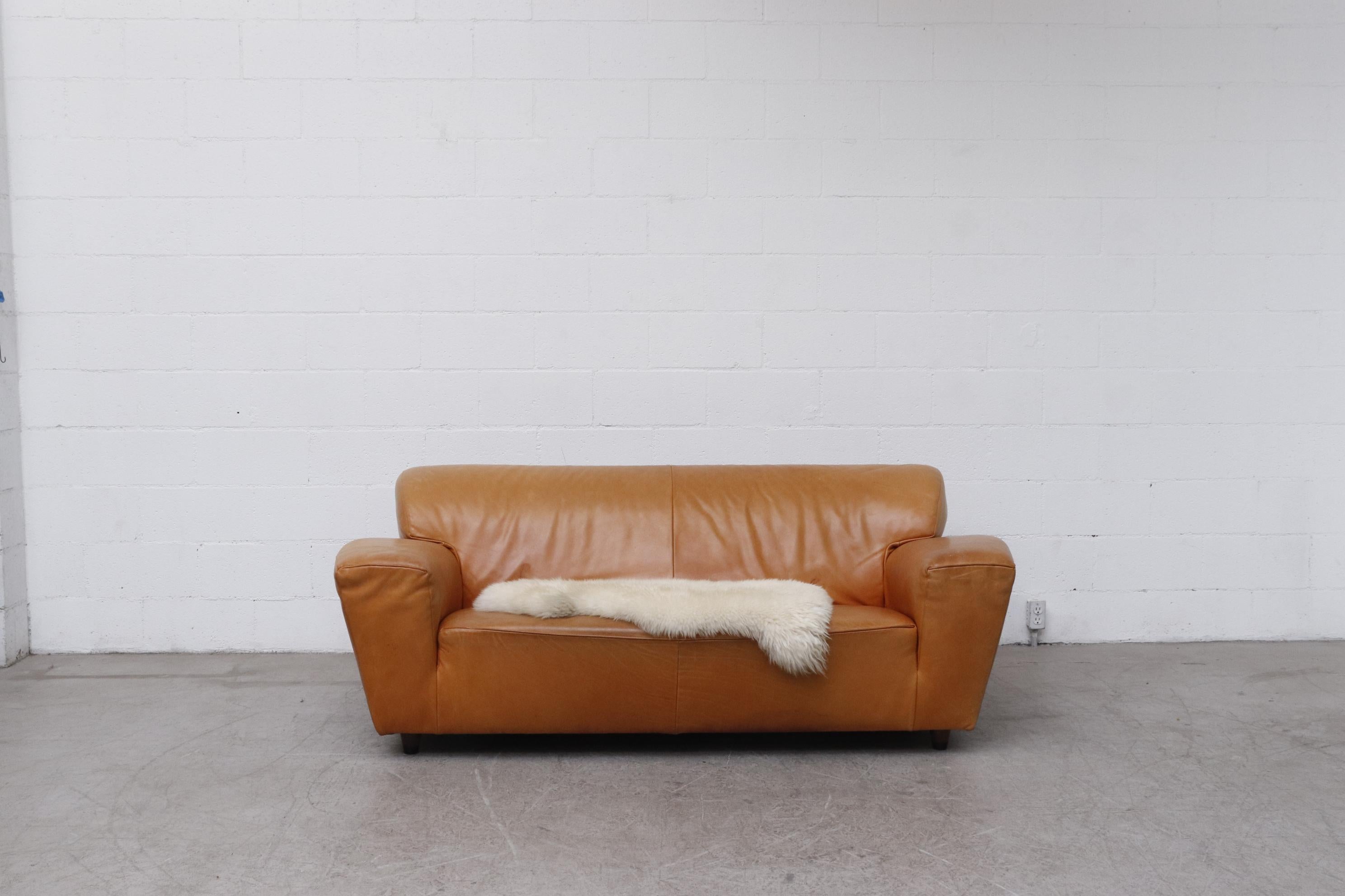 Gerard van den Berg 'Corvette' sofa in cognac leather with short tapered wood legs. In original condition with some visible wear and scratching consistent with age and use.