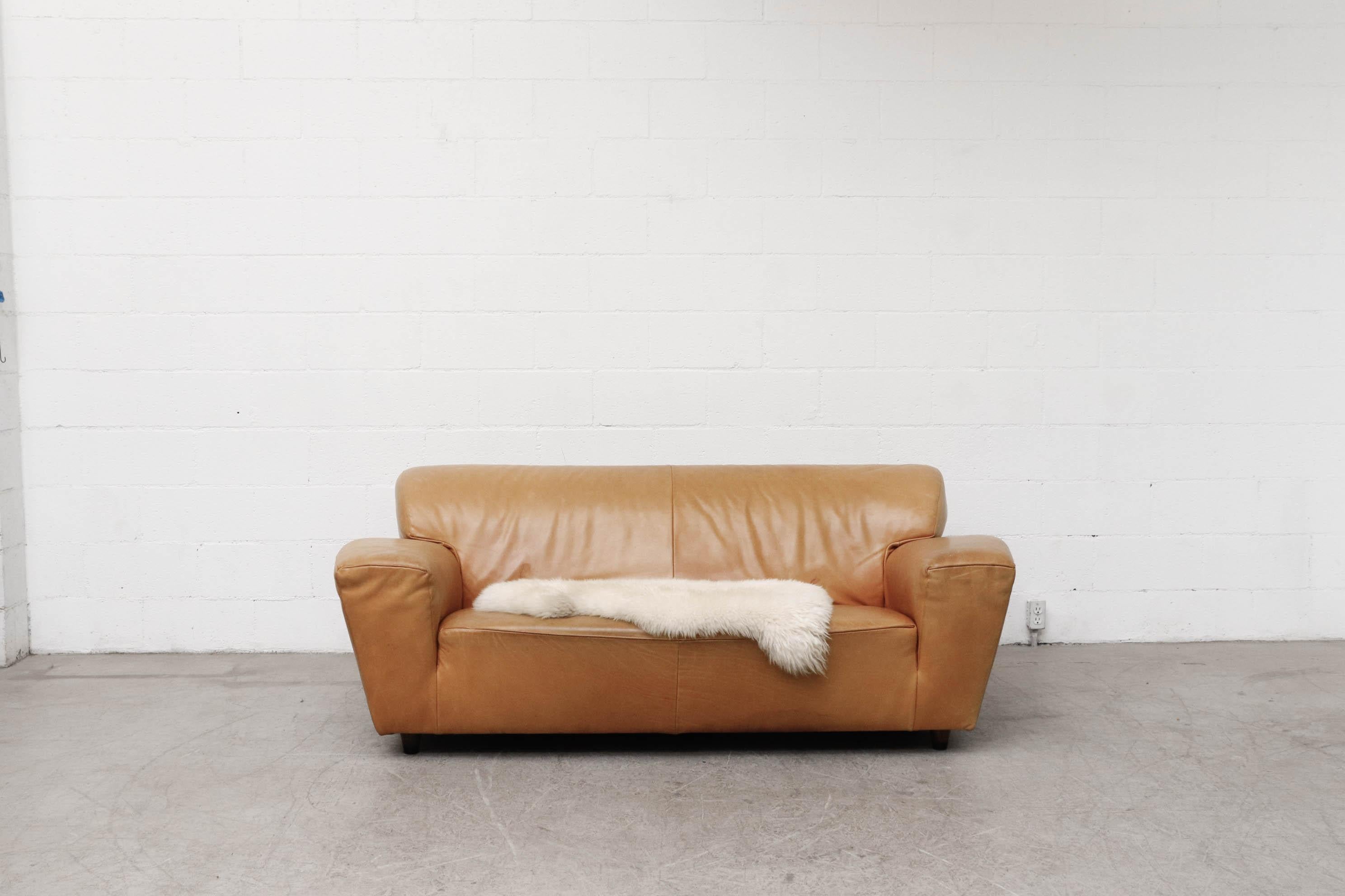 Gerard van den Berg 'Corvette' sofa in cognac leather with short tapered wood legs. In original condition with some visible wear and scratching consistent with age and use. Some denting to the leather from transport, it should relax over time.