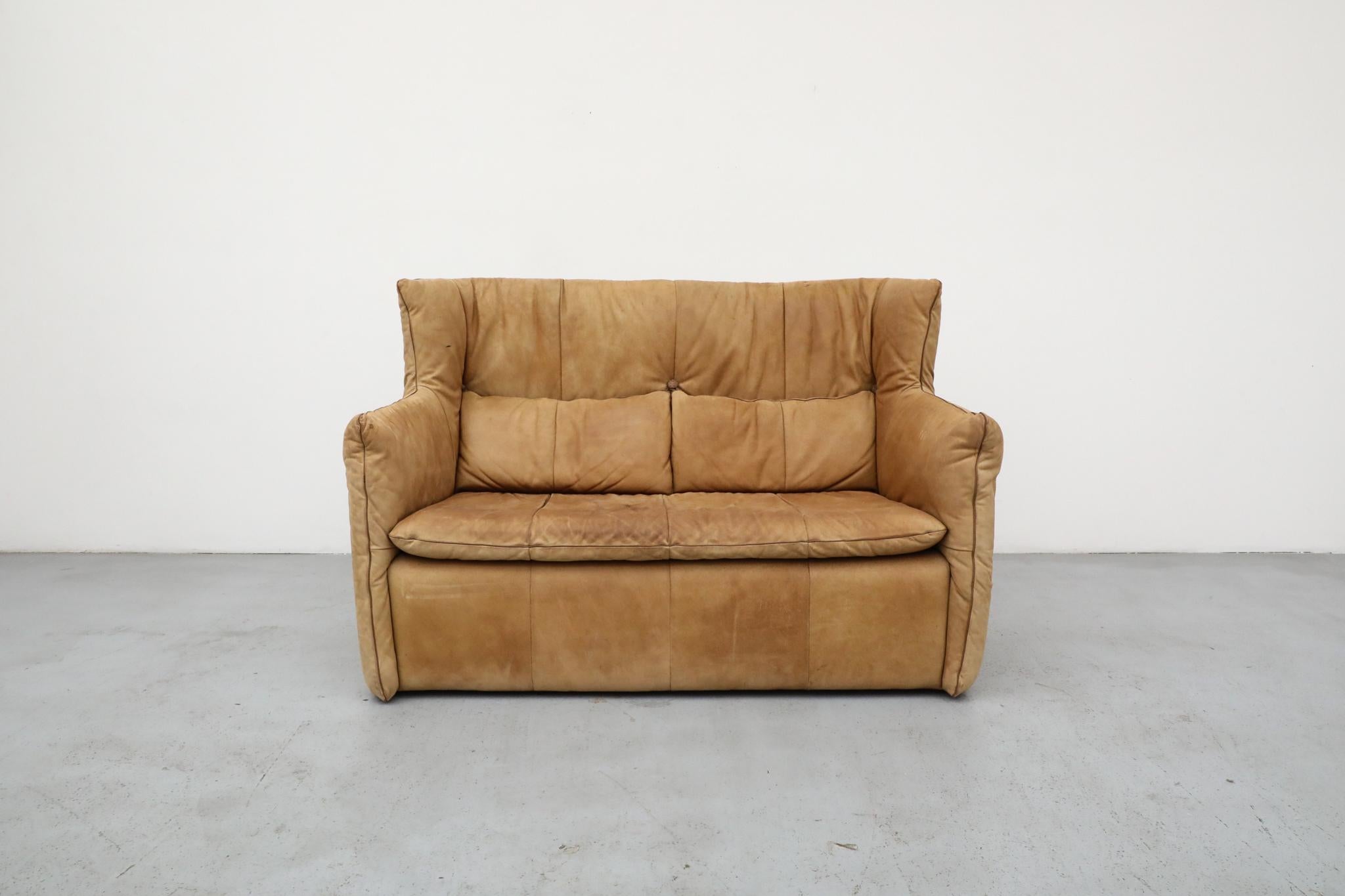 Un distintivo diseño holandés de Gerard van den Berg para Montis, este loveseat de cuero con respaldo alto combina la elegancia robusta con la comodidad. Tapizada en piel natural bellamente envejecida, la pieza incluye dos cojines de respaldo a