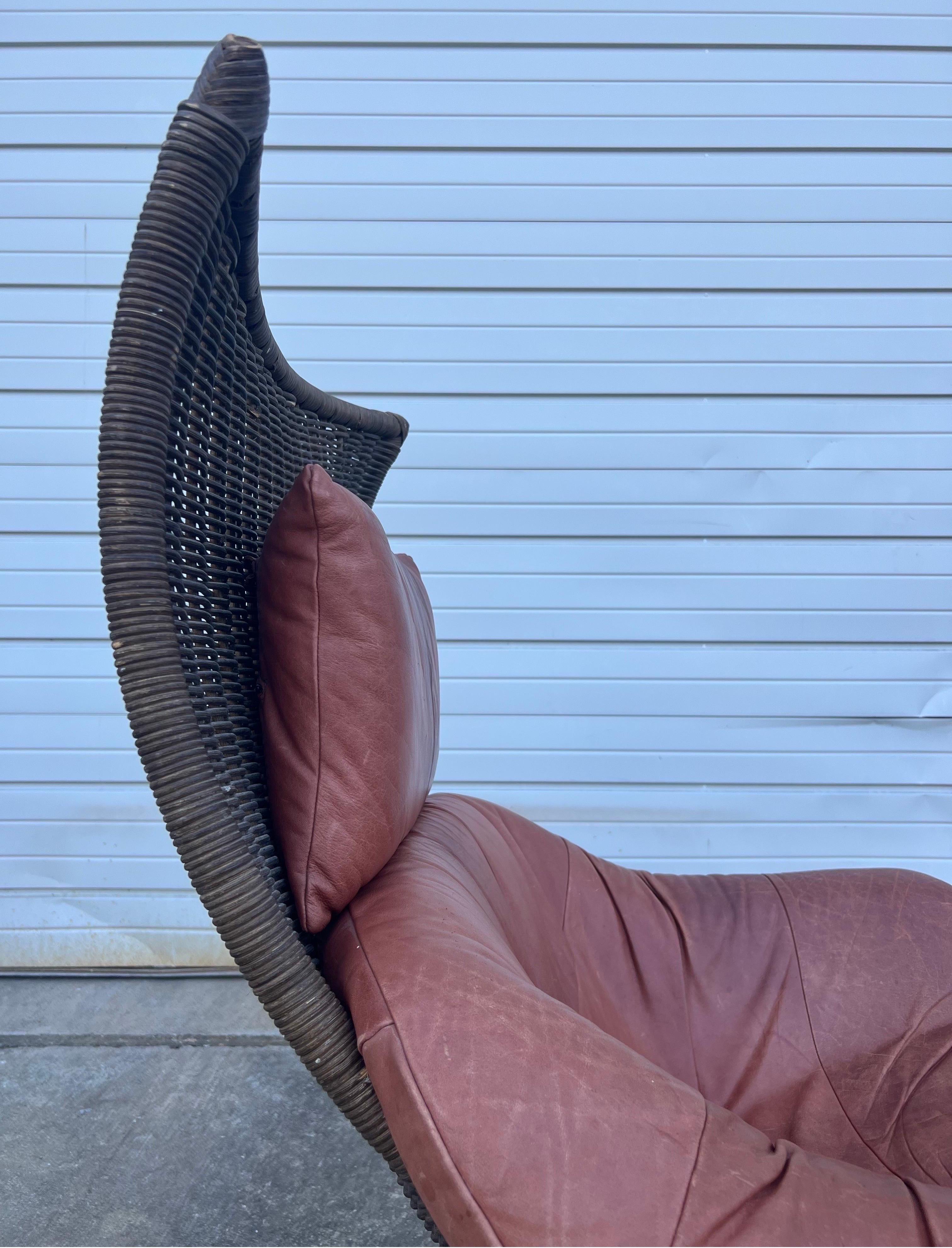 Designed by Gerard van den Berg for Montis circa 1970s. The chair is made from woven rattan in brown with original leather upholstery. The leather can be described as light brown or rose. The leather pillow is adjustable with two straps to be tied