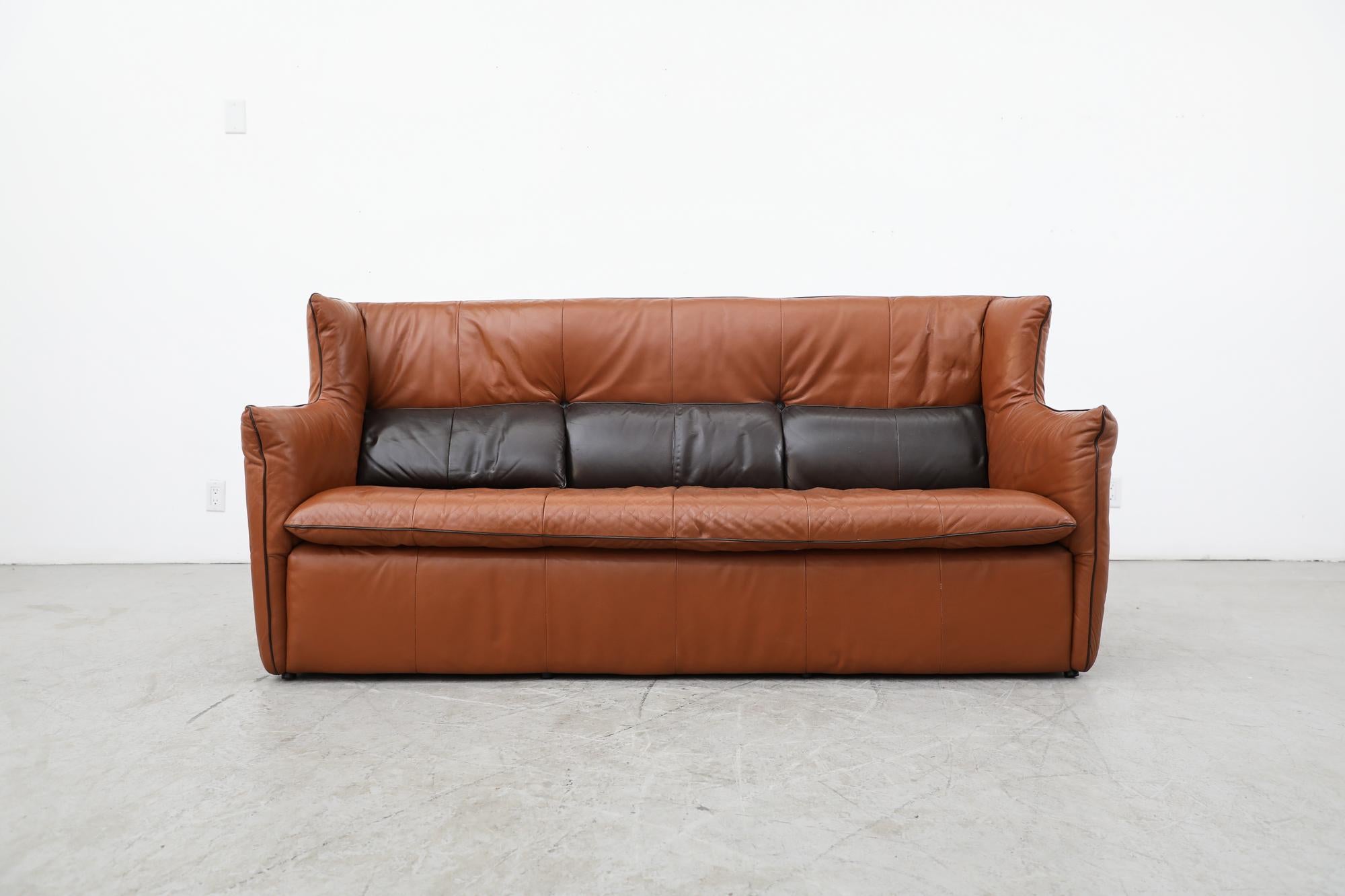 High back cognac leather sofa by Gerard van Den Berg for Montis. Cognac leather with 3 dark chocolate leather buttoned on back pillows and matching chocolate leather piping. In original condition with wear consistent with its age and use.