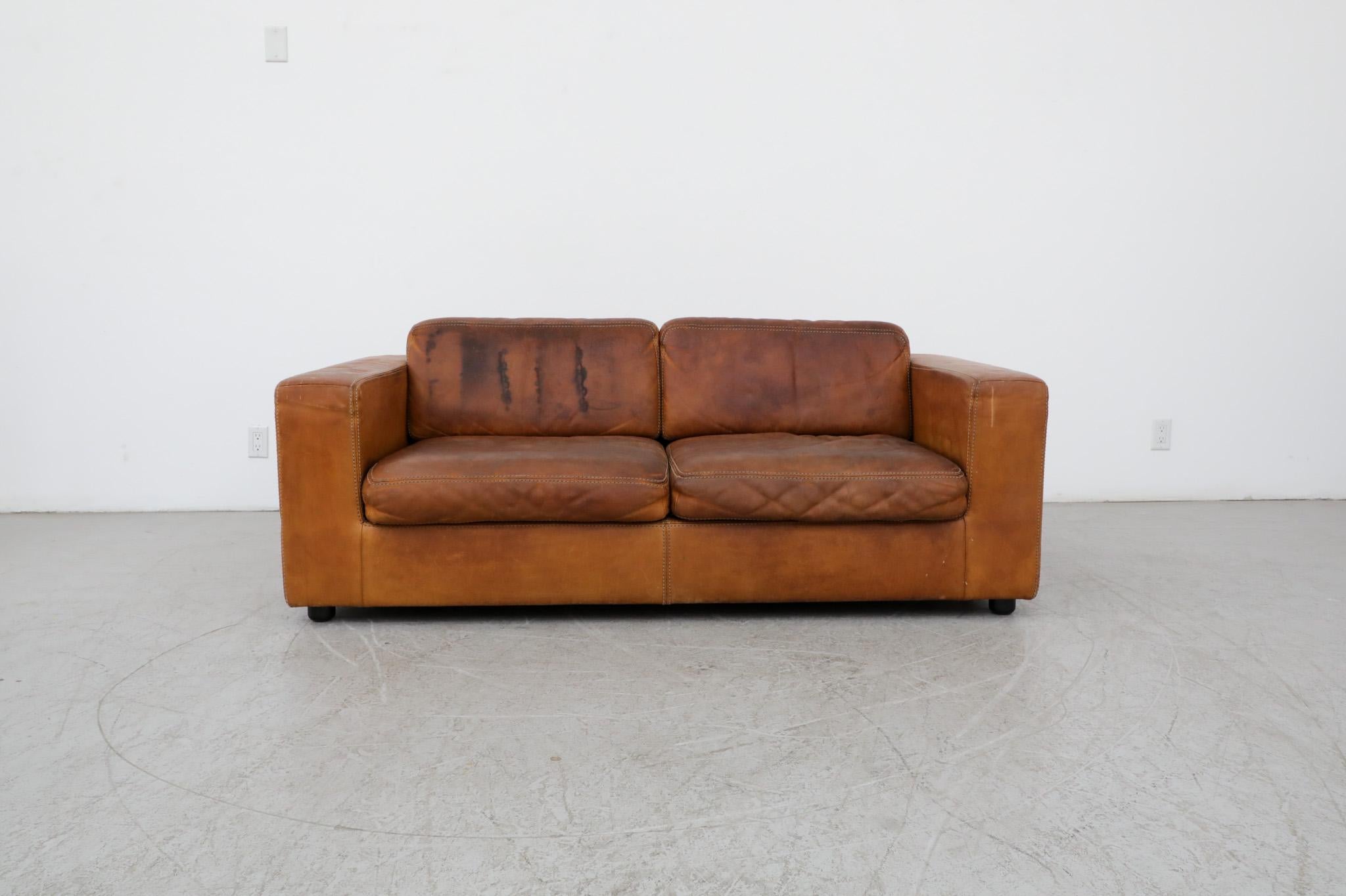 Schönes, zweisitziges Naturledersofa aus der Jahrhundertmitte mit tiefer Patina. Hergestellt von Durlet, Belgien. Dieses bequeme Softform-Sofa sitzt niedrig und besteht aus dickem Leder mit großen Nähten. In gut geliebten Originalzustand mit einigen