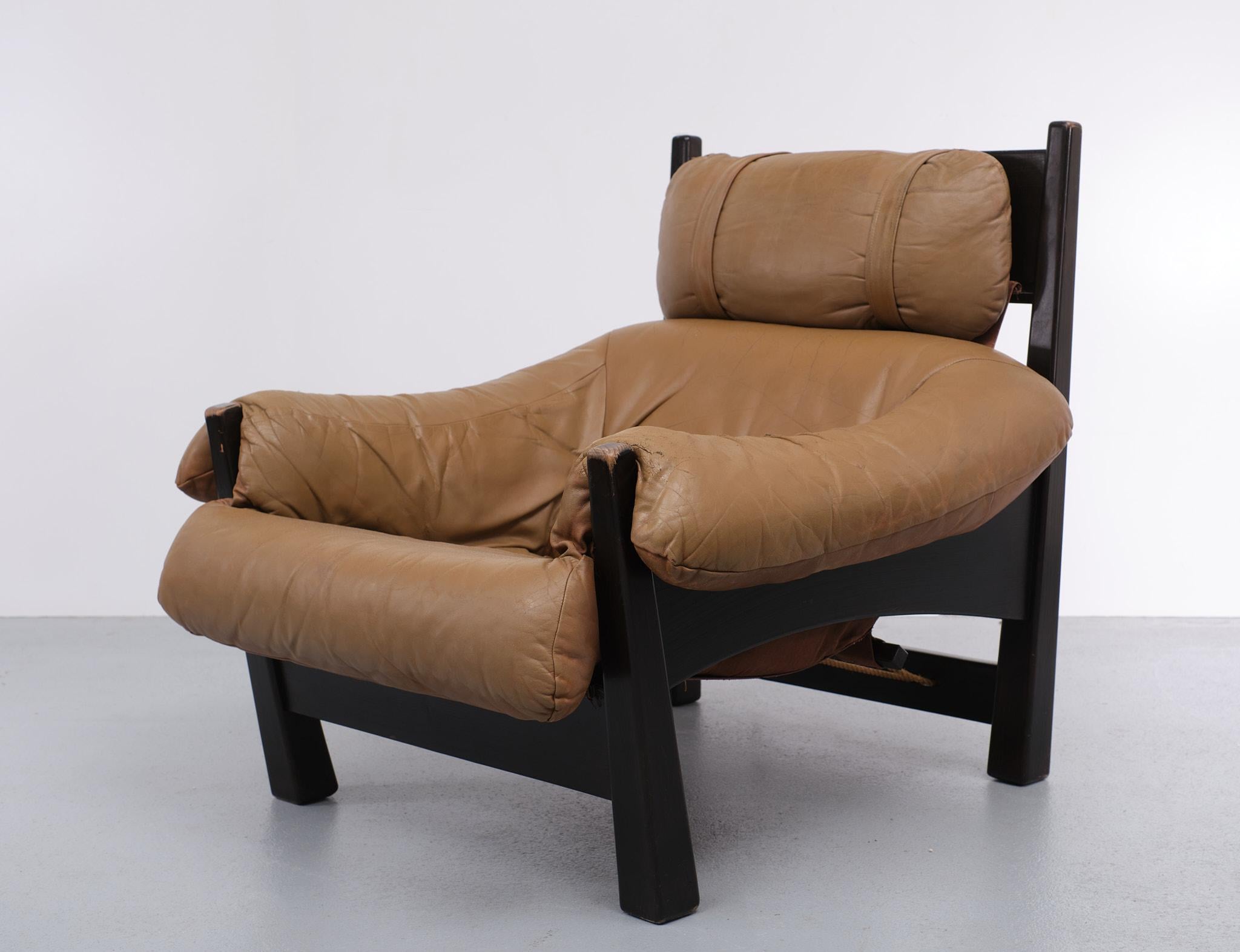 Lounge chair by Gerard van den Berg for Montis, the Netherlands 1970s 
pine/fir/spruce frame, slung/hung brown canvas support.
shaped cushion of soft camel or caramel colored leather, faded and sun bleached, with patina, seat repaired. one tear in