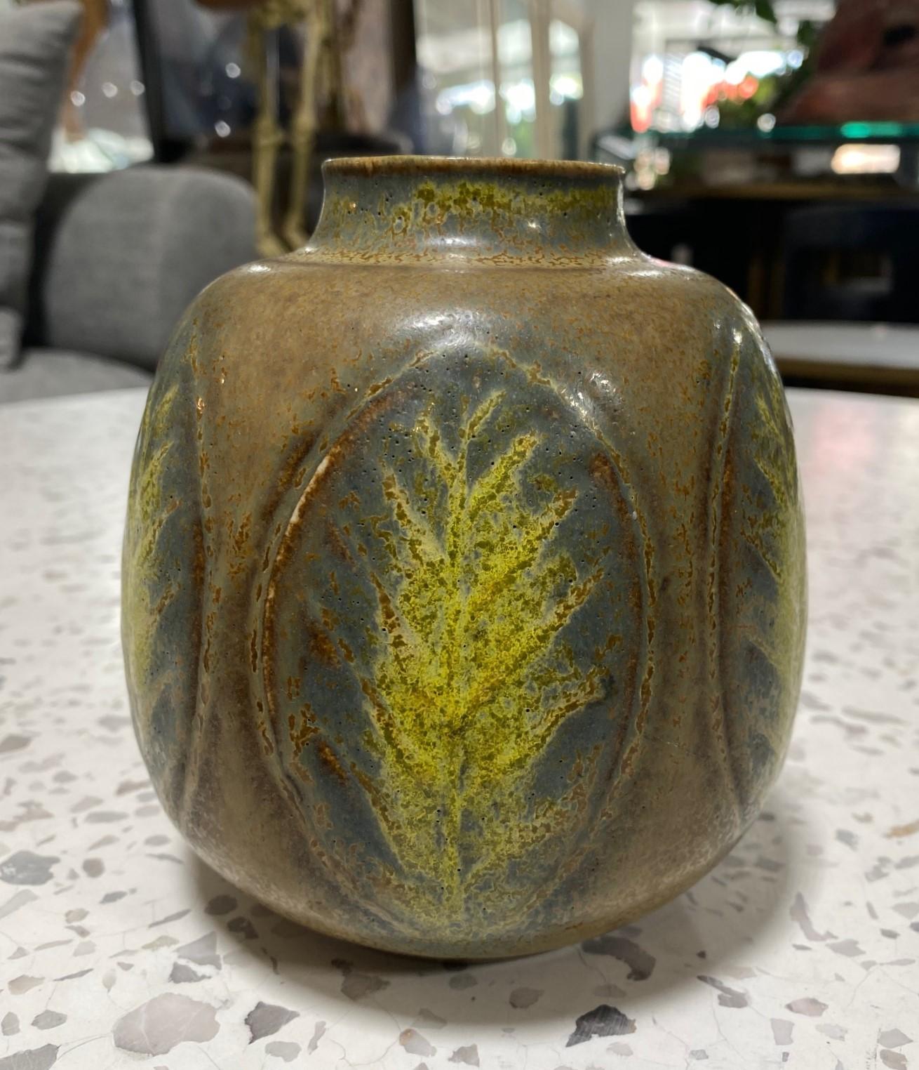 A gorgeous, wonderfully designed, and glazed Mid-Century Modern Danish/Scandinavian art vase by Gerd Bogelund for Royal Copenhagen featuring leaf decoration and a semi-gloss pale brown glaze.  

The piece is signed by Bogelund with his incised 