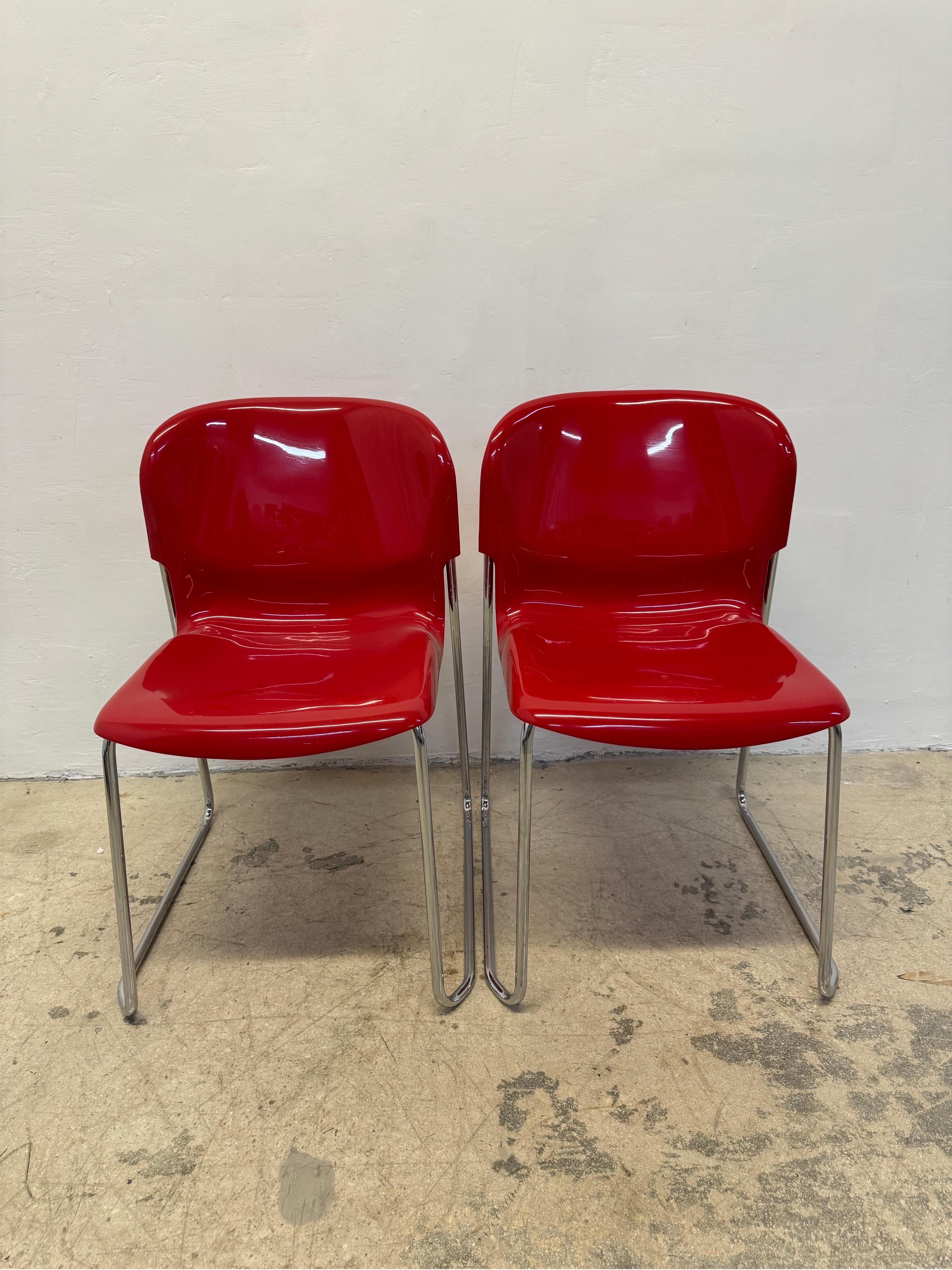 Pair of stackable dining chairs with glossy red moulded plastic seats on tubular chrome legs designed by Gerd Lange for Atelier International, 1980s. Originally designed in the 1960s, this set was produced in the 1980s by Atelier International USA.
