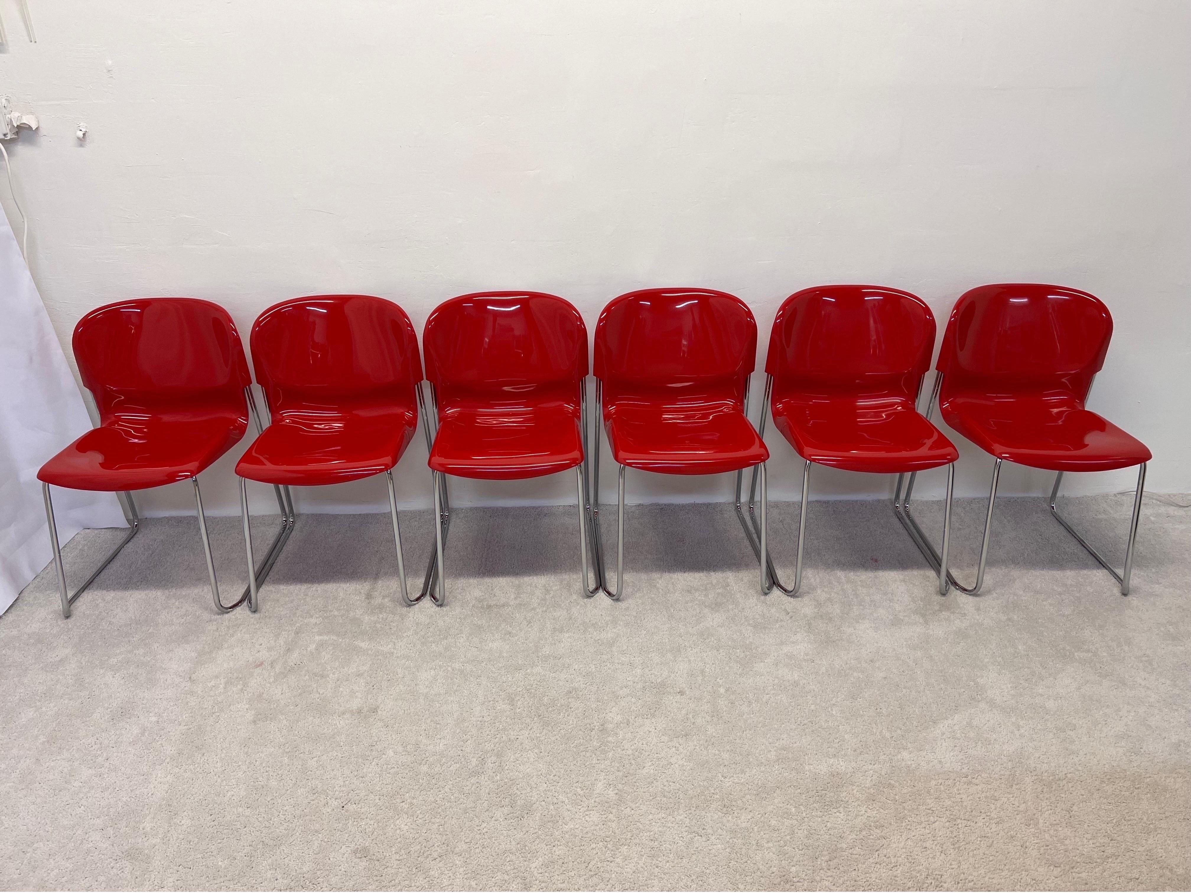 Satz von sechs stapelbaren Esszimmerstühlen mit glänzend roten Kunststoffsitzen auf verchromten Rohrbeinen, entworfen von Gerd Lange für Atelier International, 1980er Jahre. Dieses Set wurde ursprünglich in den 1960er Jahren entworfen und in den