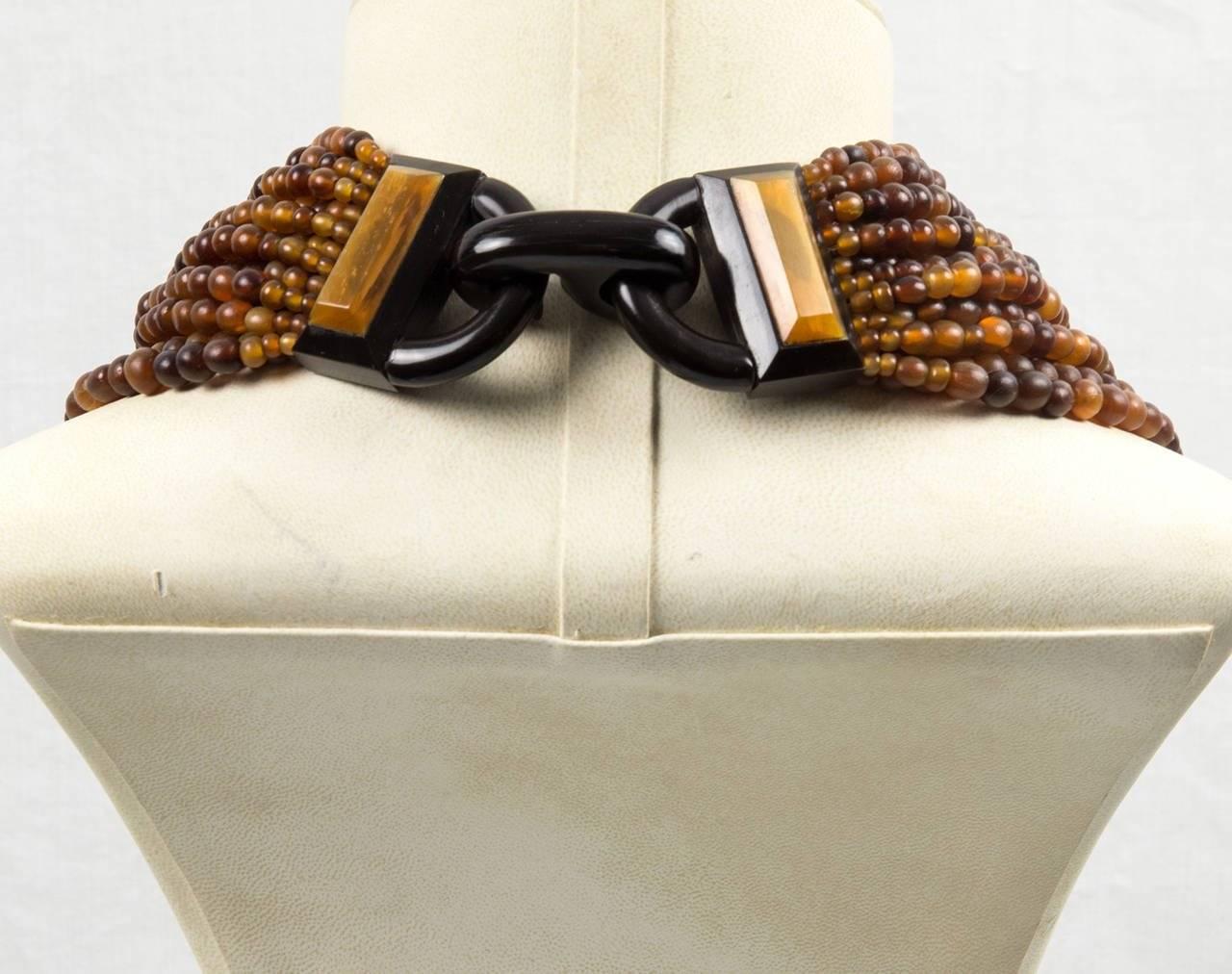 Dramatic designer necklace by husband and wife team Gerda Lynggaard & Nikolai Monies of Copenhagen Denmark, known for large scale high end costume jewelry incorporating natural materials; Rows and rows of rich Natural Horn Beads are gathered with an