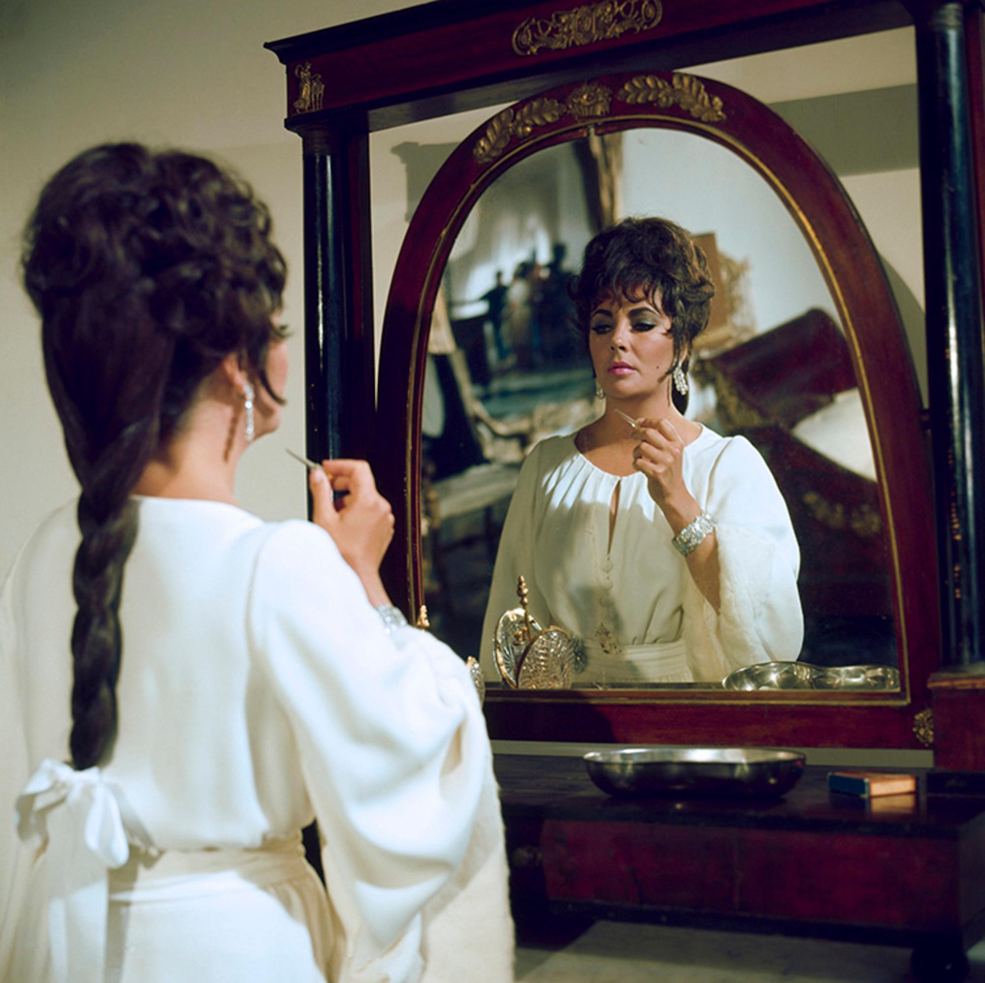 Title: Elizabeth Taylor (in the Mirror) on Set of 'Boom!'

C-type print signed and numbered by Gered Mankowitz

Elizabeth Taylor photographed on set of Joseph Losey’s romantic drama film ‘Boom!’ in Sardinia, 1968.

Available Sizes:
16" x 20” Edition