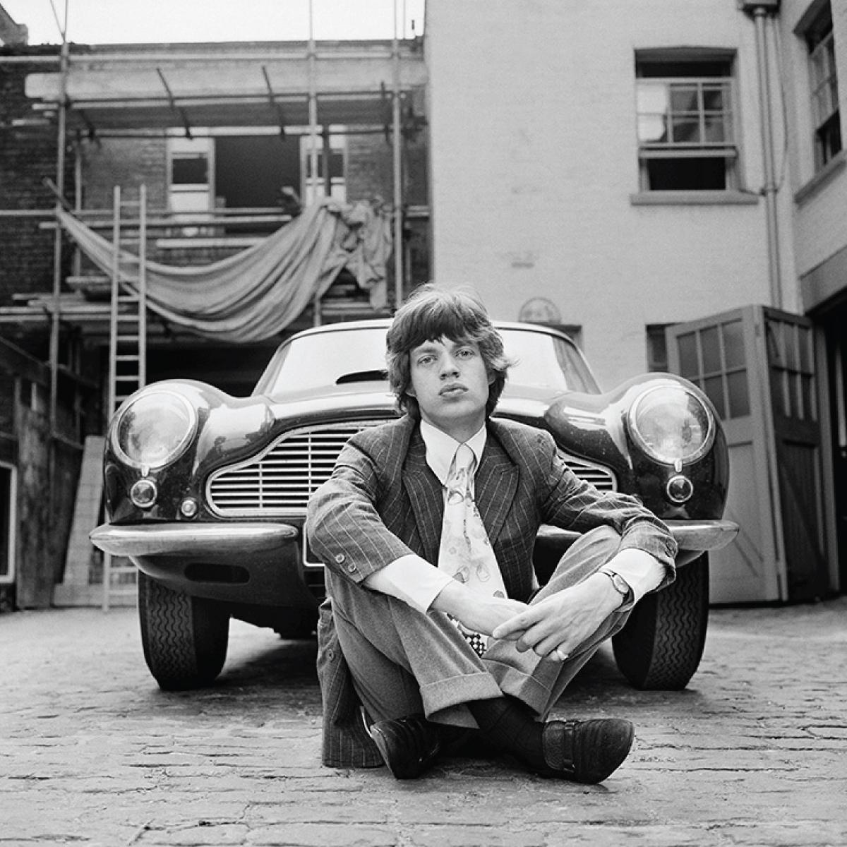 Mick Jagger von den Rolling Stones mit seinem geliebten Aston Martin DB6, aufgenommen vor seiner Londoner Wohnung im Jahr 1966 von Gered Mankowitz.

"Ich habe eine Reihe von Fotos von jedem Bandmitglied zu Hause geschossen, damit sie nicht ertragen