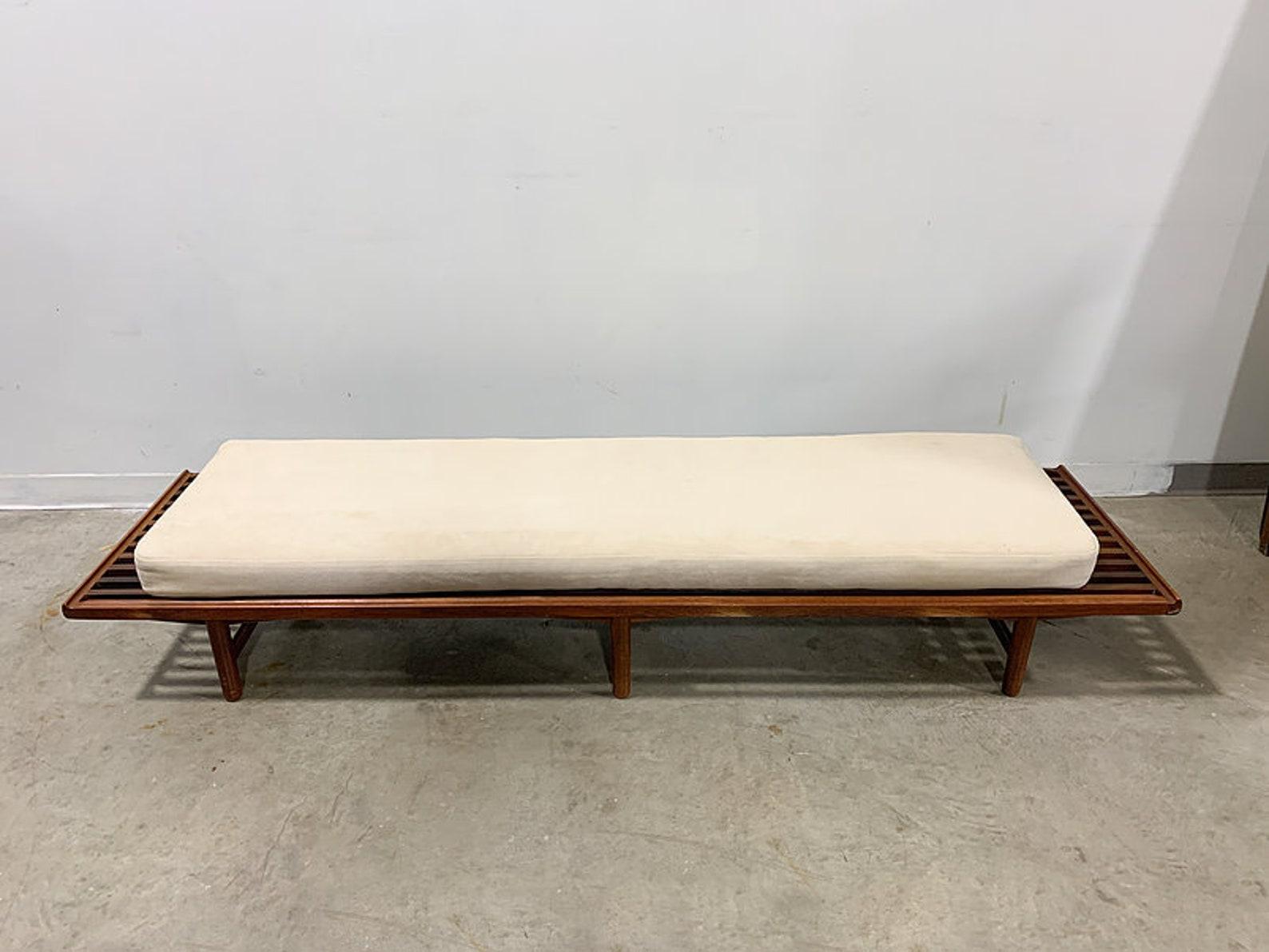 Beautifully detailed solid teak slat bench designed by Gerhard Berg for P.I. Langlo Fabrikker of Norway circa 1959. Originally designed as part of a modular seating system, this bench works equally well with a cushion as shown and could also be used
