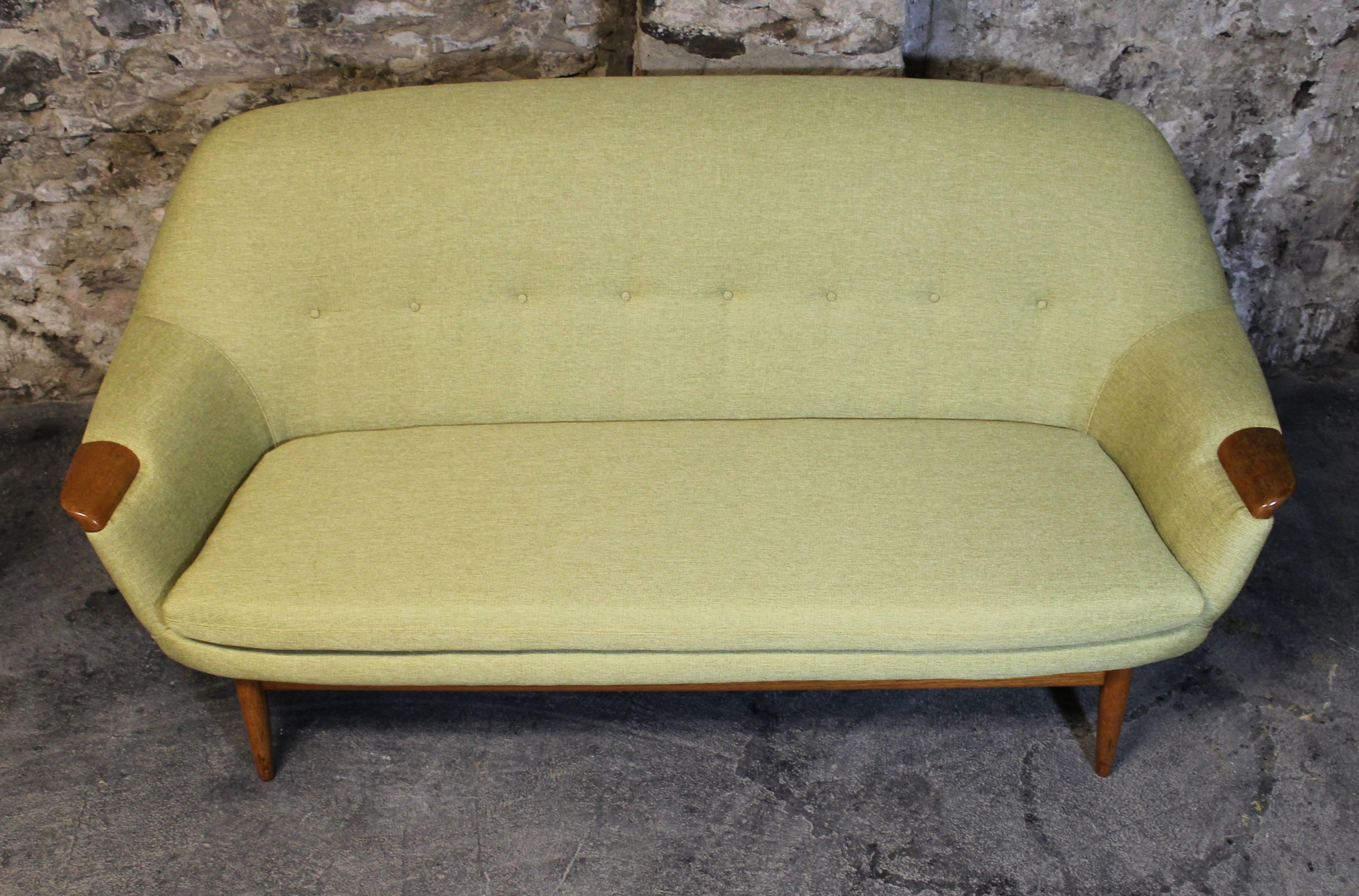 Gerhard Berg designed this scarce modernist sofa LK Hjelle of Norway in the golden age of Norwegian furniture design. It has been newly upholstered and sits on a teak base with tapered legs and sculpted 'paw' arms placed on either