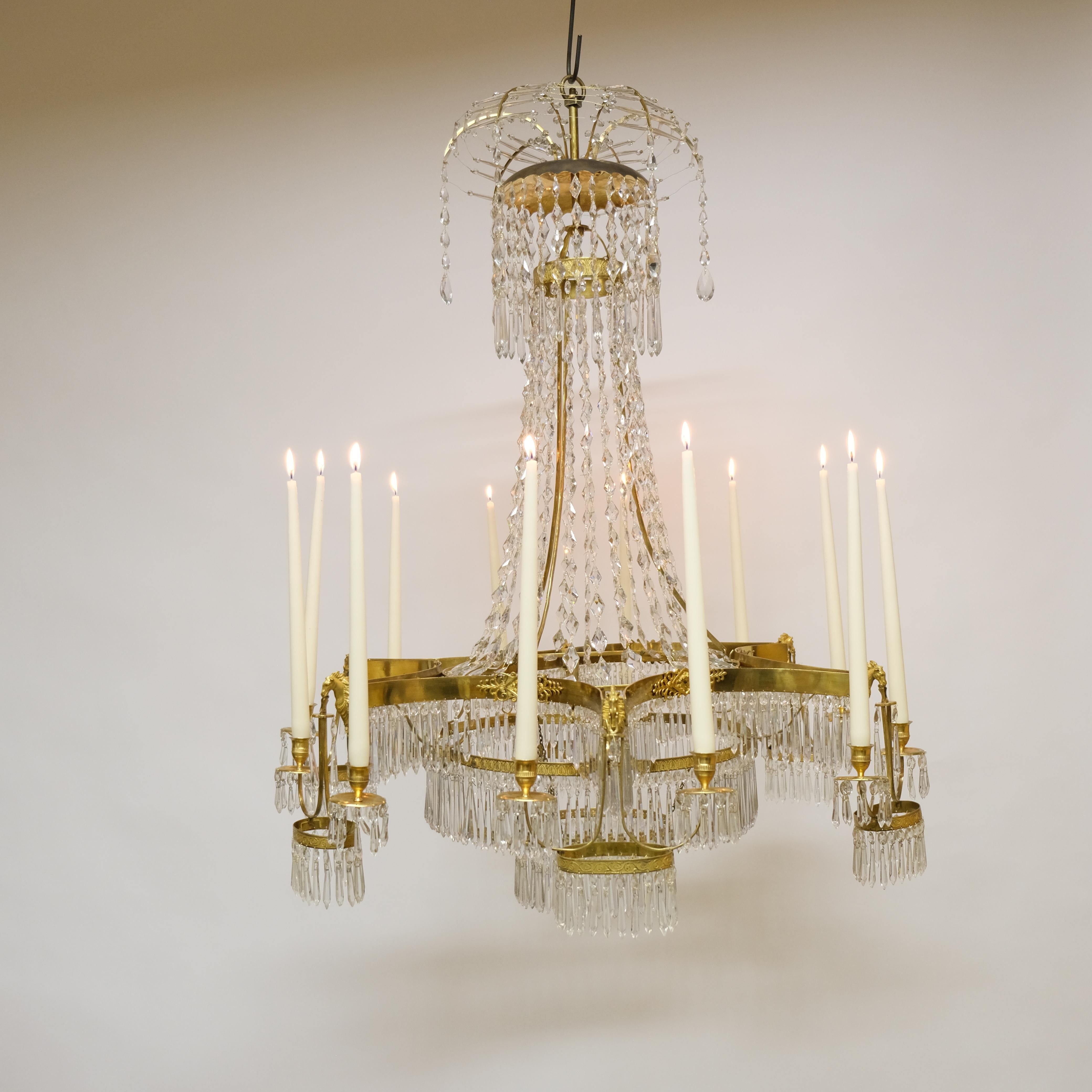 Un grande lampadario Impero a 12 luci con stupefacenti decorazioni di teste di cavallo etc. Il design è molto architettonico e l'