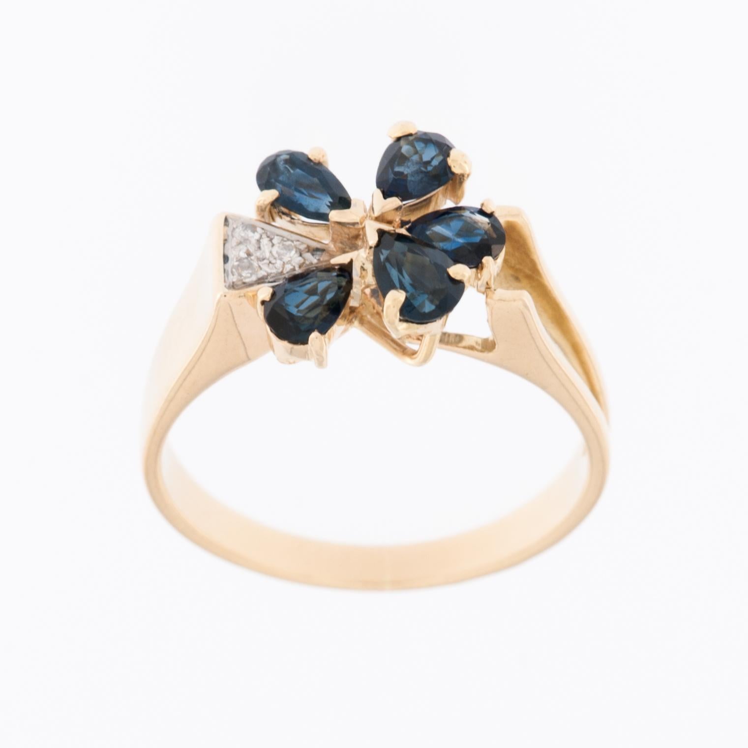 Der German Ring aus 14-karätigem Gelbgold mit Diamanten und Saphiren ist ein wunderschönes Schmuckstück, das für sein elegantes und kompliziertes Blumendesign bekannt ist. 

Der Ring ist aus 14-karätigem (14kt) Gelbgold gefertigt, das ihm ein warmes