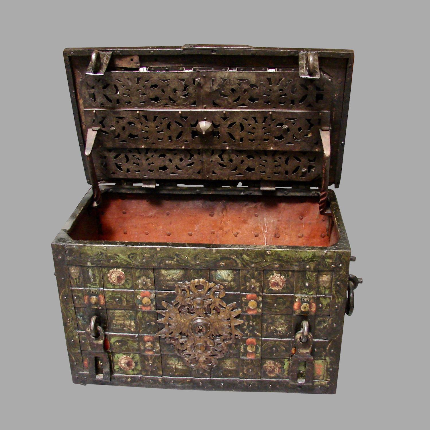 An impressive late 17th century Nuremberg wrought iron painted armada chest opening to reveal an elaborate working lock mechanism covered by an engraved pierced steel screen, the sides with twisted rope form iron carrying handles, circa 1650, shown