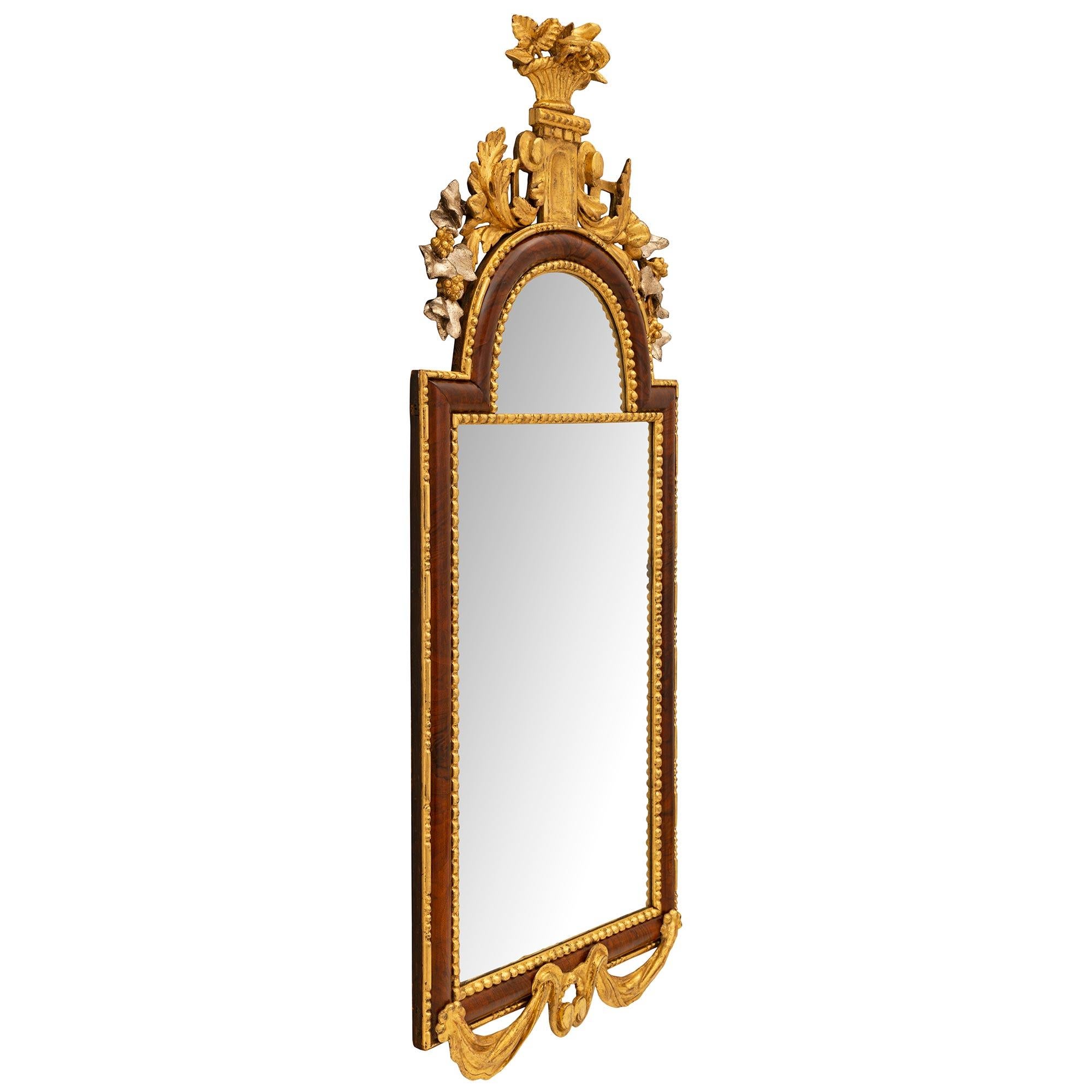 An exceptional and very unique German 18th century neo-classical period burl Walnut, giltwood, and Mecca mirror. The mirror retains its original mirror plates each framed within a most decorative beaded wrap around giltwood band. The frame showcases